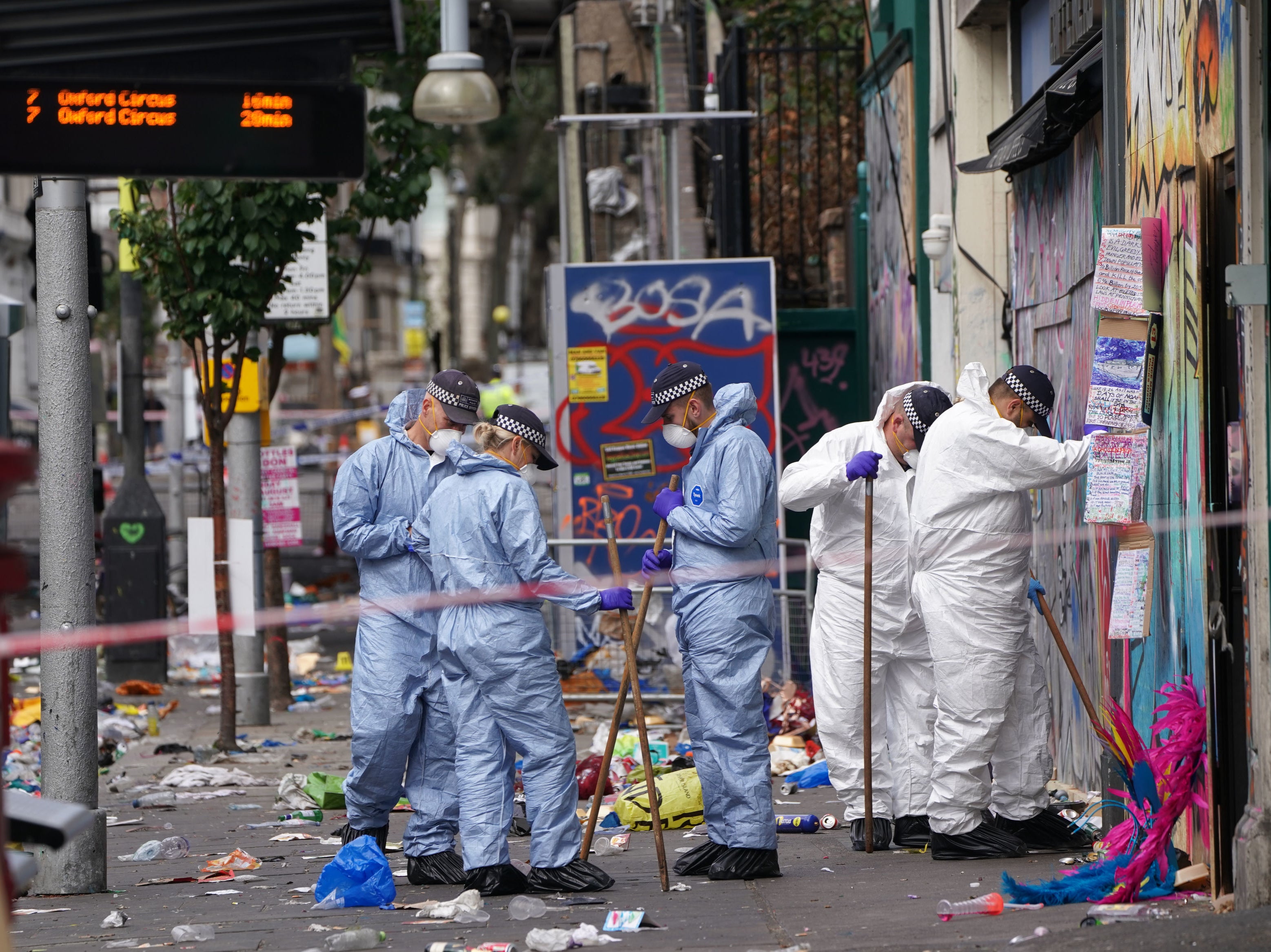 Forensic officers comb the scene in Ladbroke Grove, west London, after the rapper was stabbed