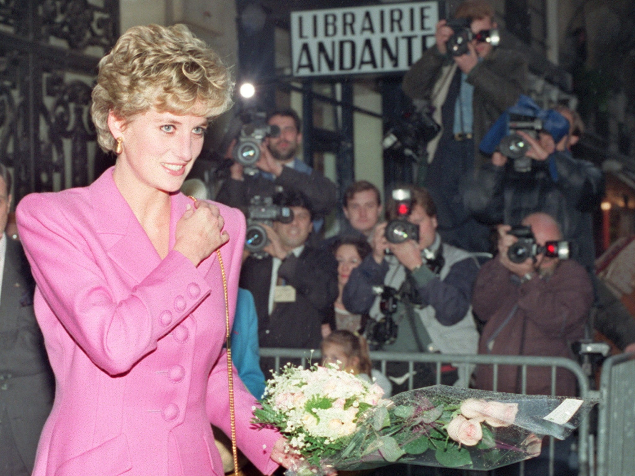 Diana, Princess of Wales is surrounded by paparazzi after an event in 1992