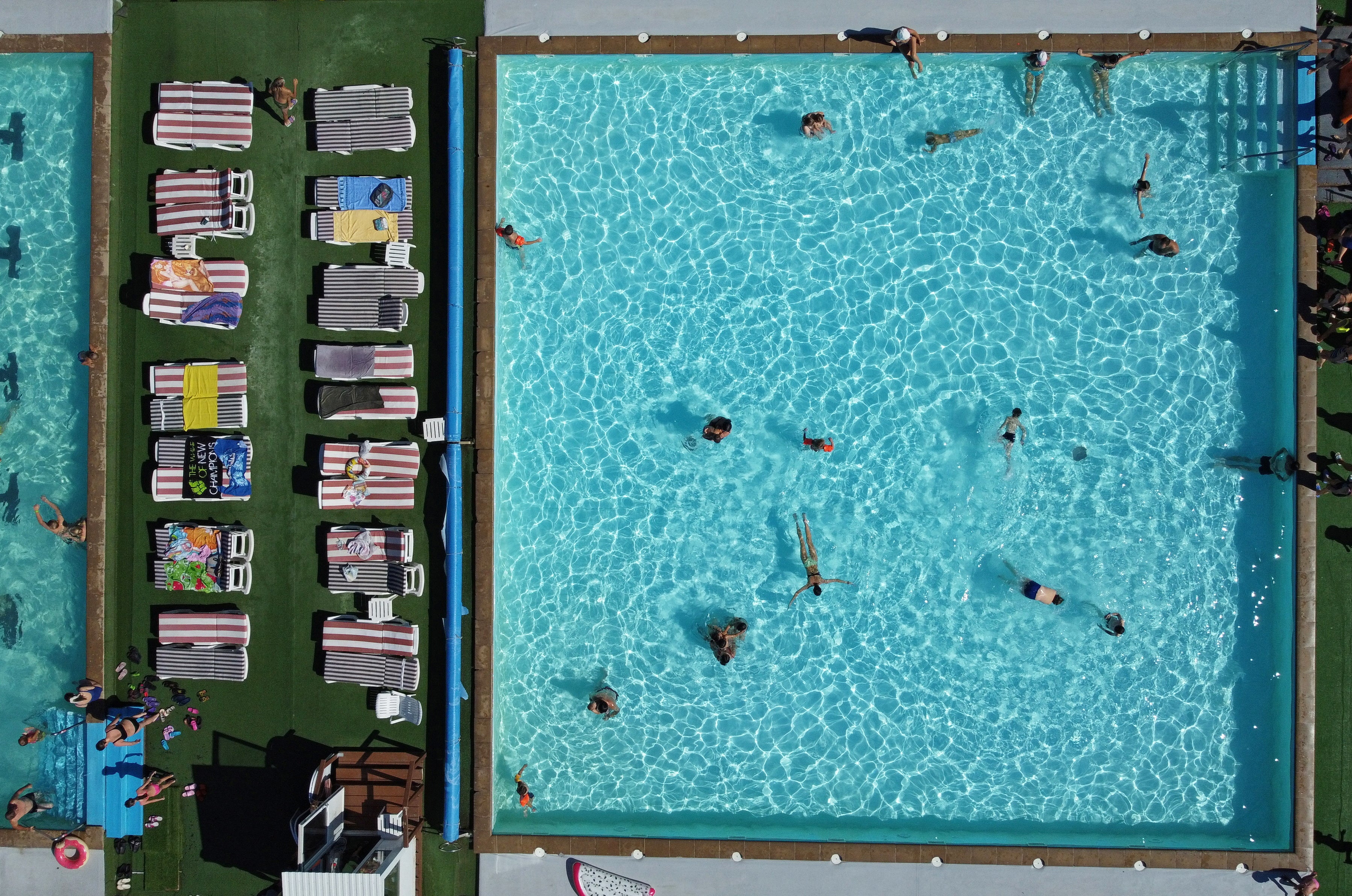 File: people relax in a swimming pool on a summer day