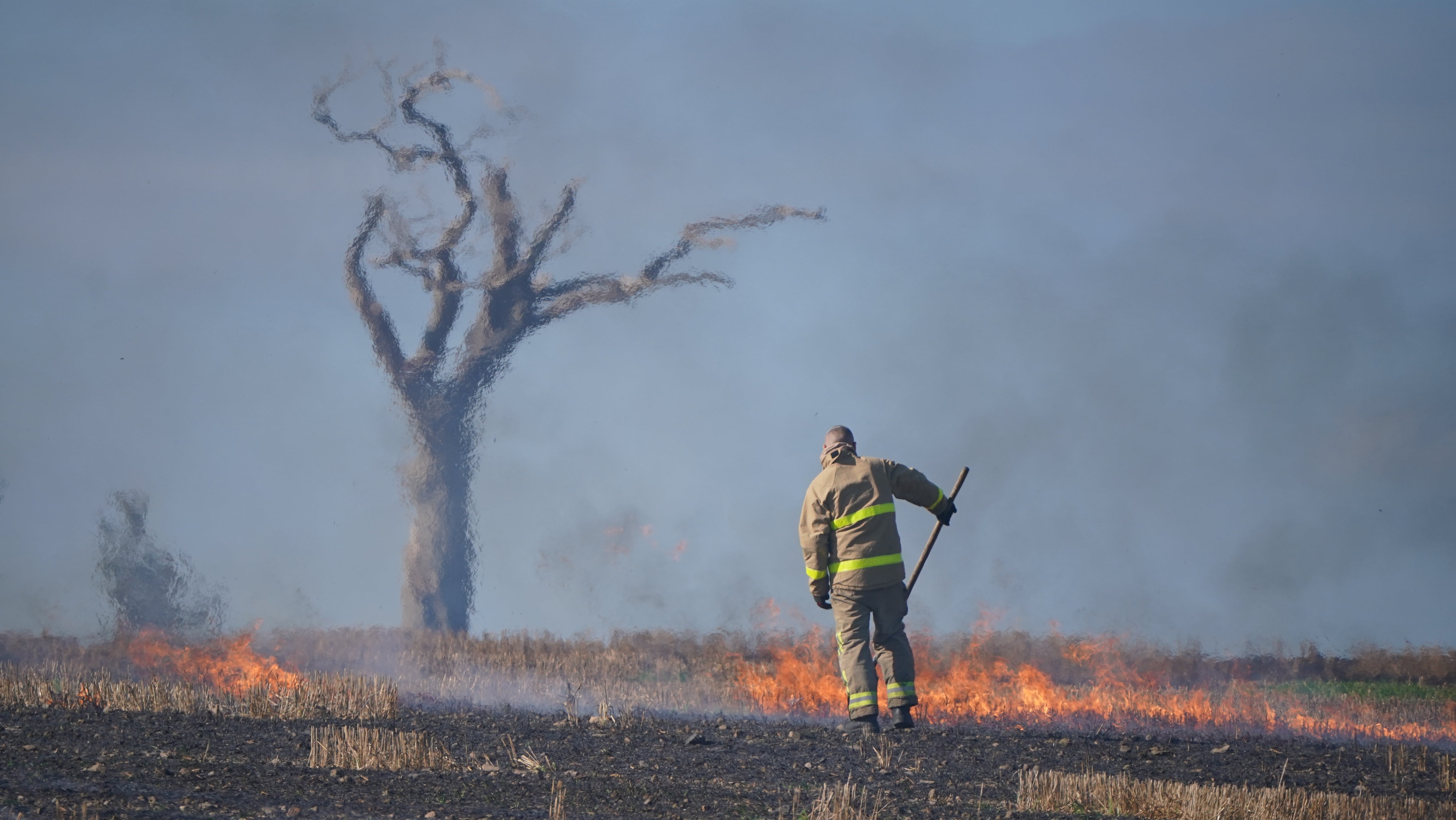 A firefighter tackles a blaze in a Co Down field made famous by the music star Rihanna (Niall Carson/PA)