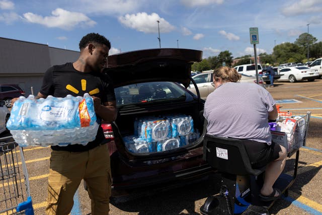 <p>People load water bottles into a car on Wednesday. Jackson, Mississippi is to go without reliable, clean water for an ‘indefinite’ period of time</p>