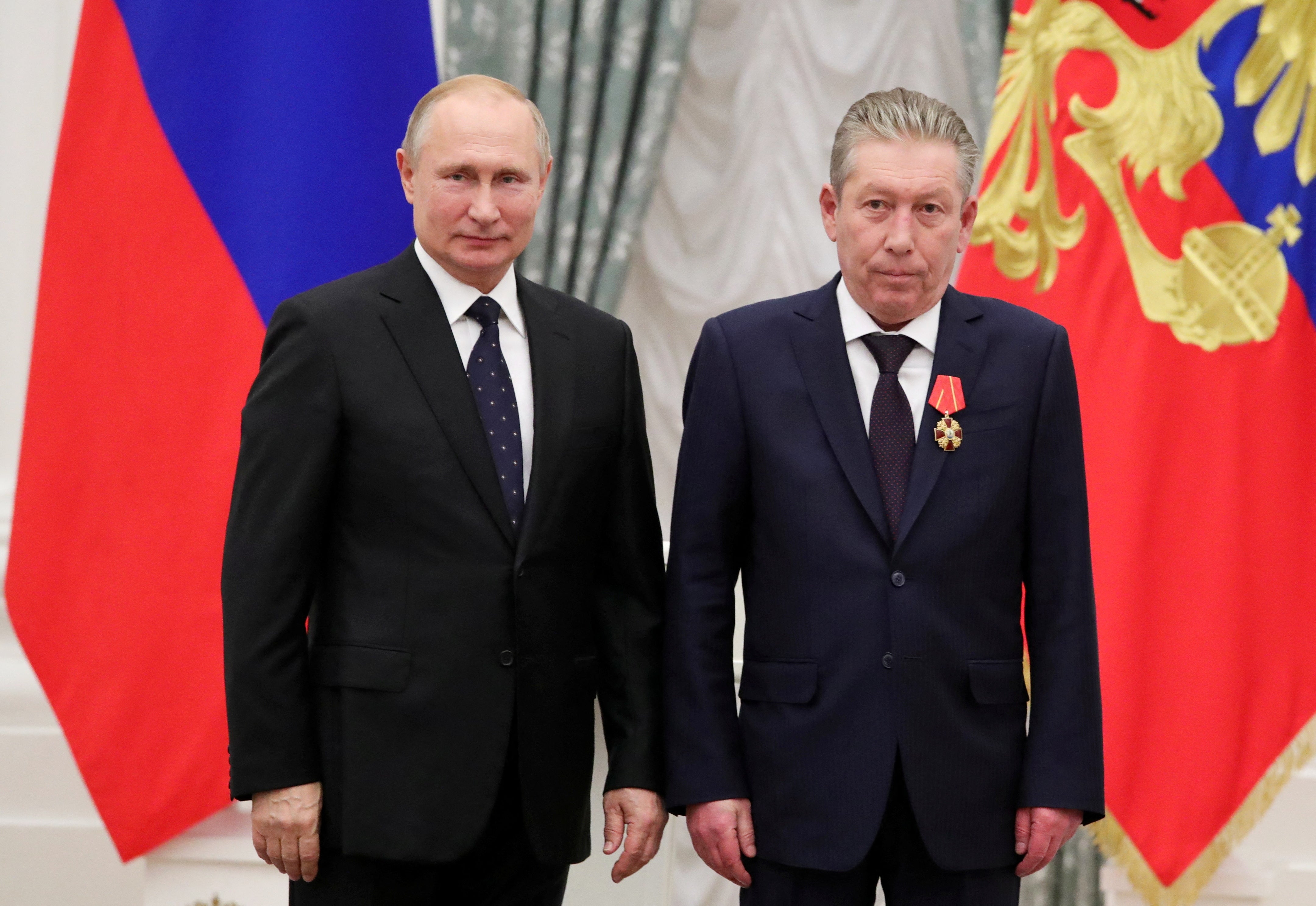 Russian president Vladimir Putin stands next to first executive vice-president of oil producer Lukoil, Ravil Maganov