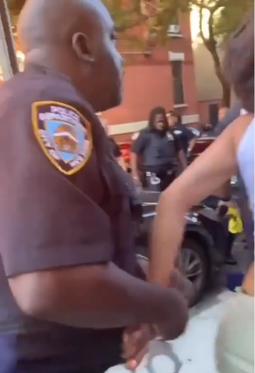 Crum is seen getting handcuffed after an NYPD officer punched her to the ground after she struck the officer on the shoulder with an open-faced hand