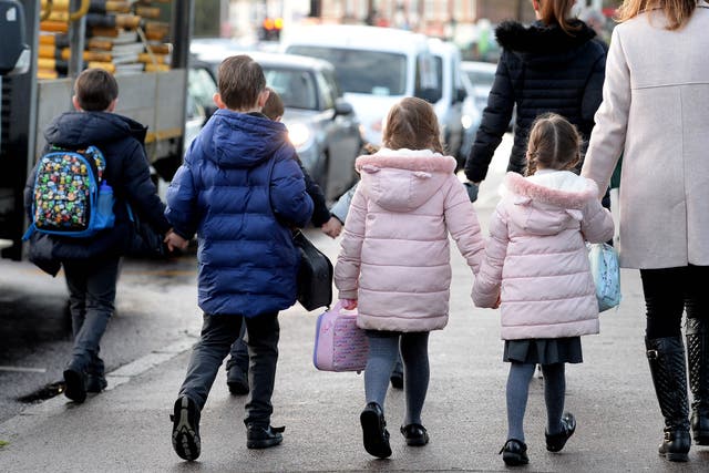 Parents walk their children to school (Nick Ansell/PA)