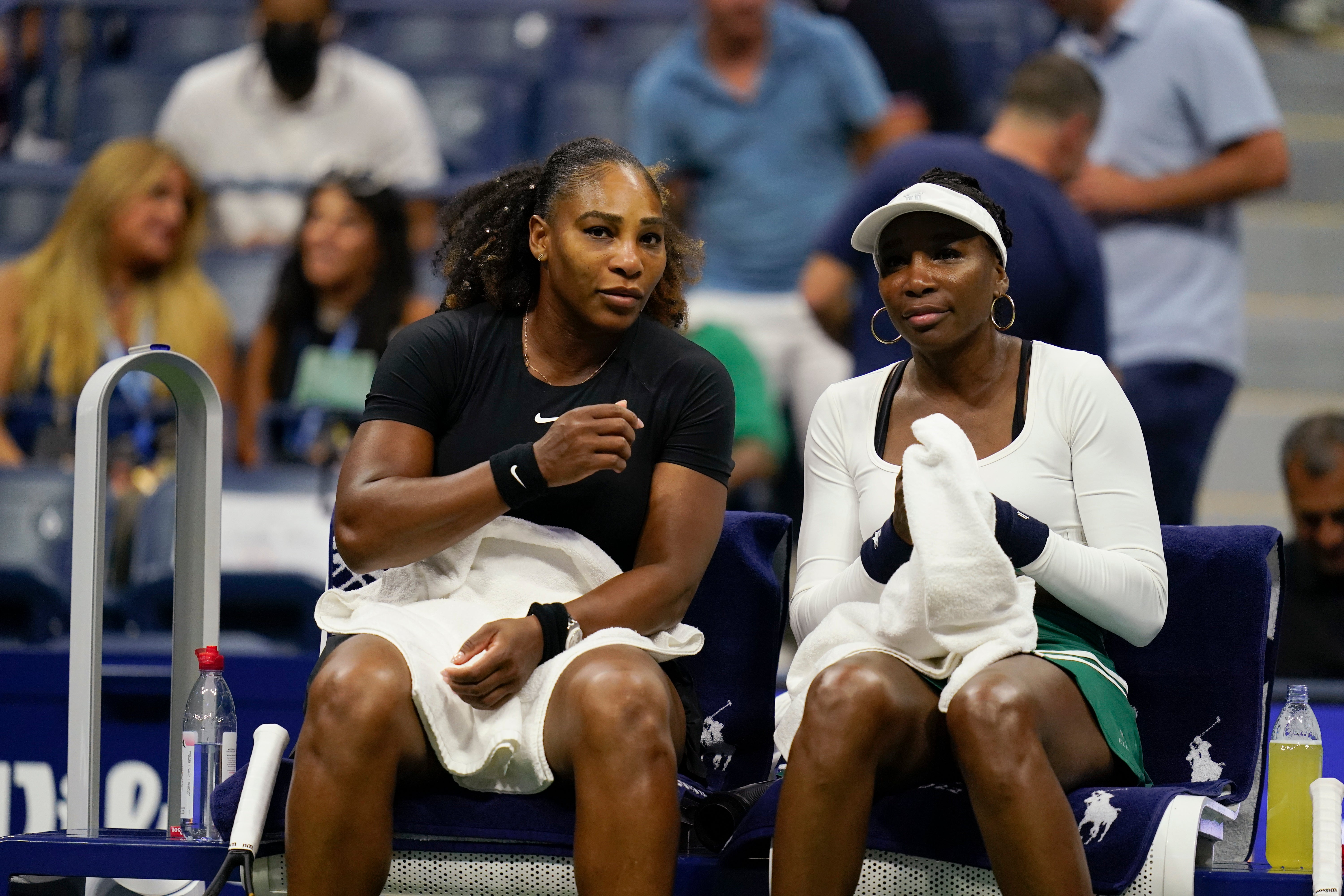 Serena (left) and Venus Williams talk at a change of ends (Charles Krupa/AP)