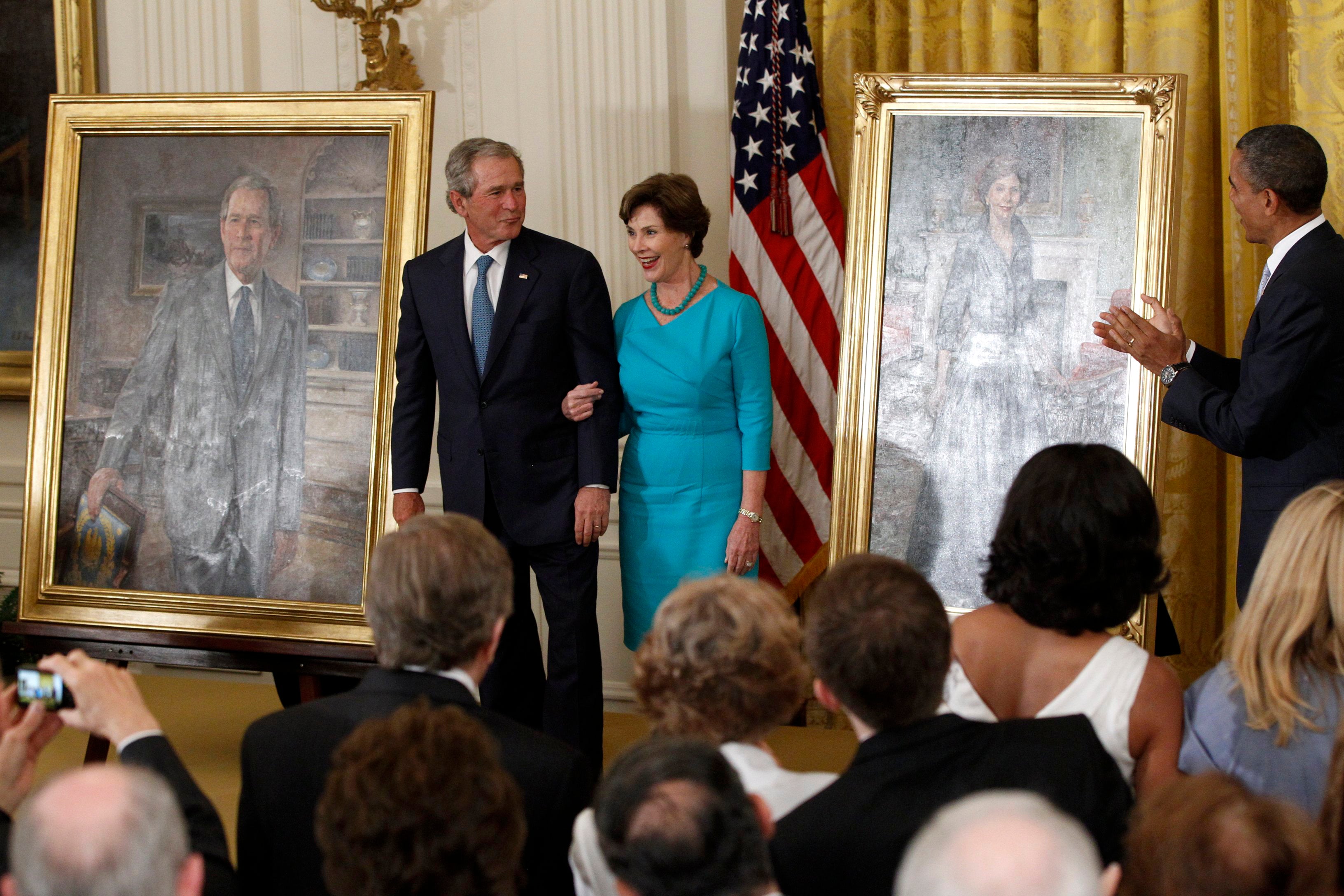 Barack Obama applauds as George W Bush and his wife Laura see their portraits added to the White House collection on 31 May 2012