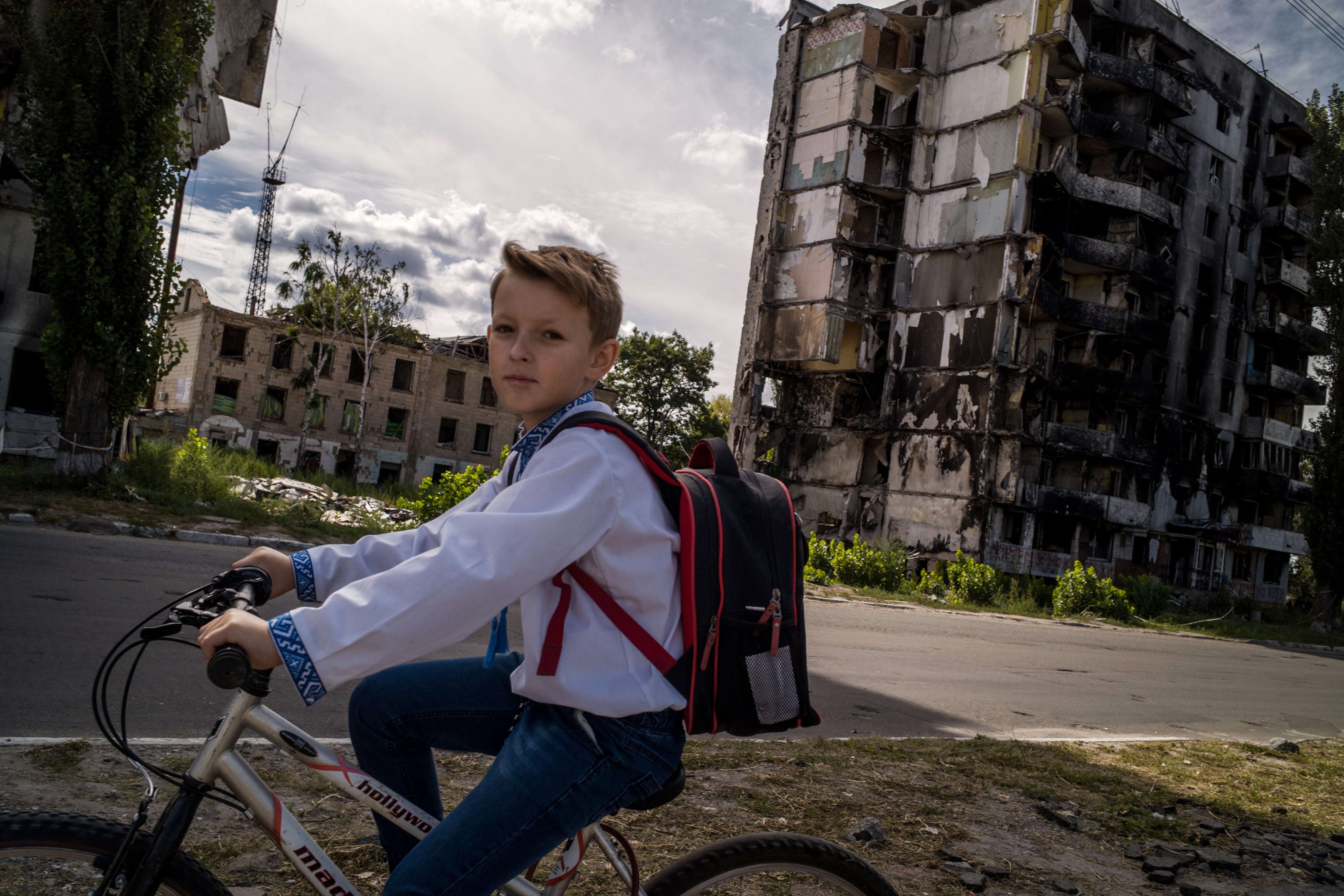 A student passes the remnants of a bombed building