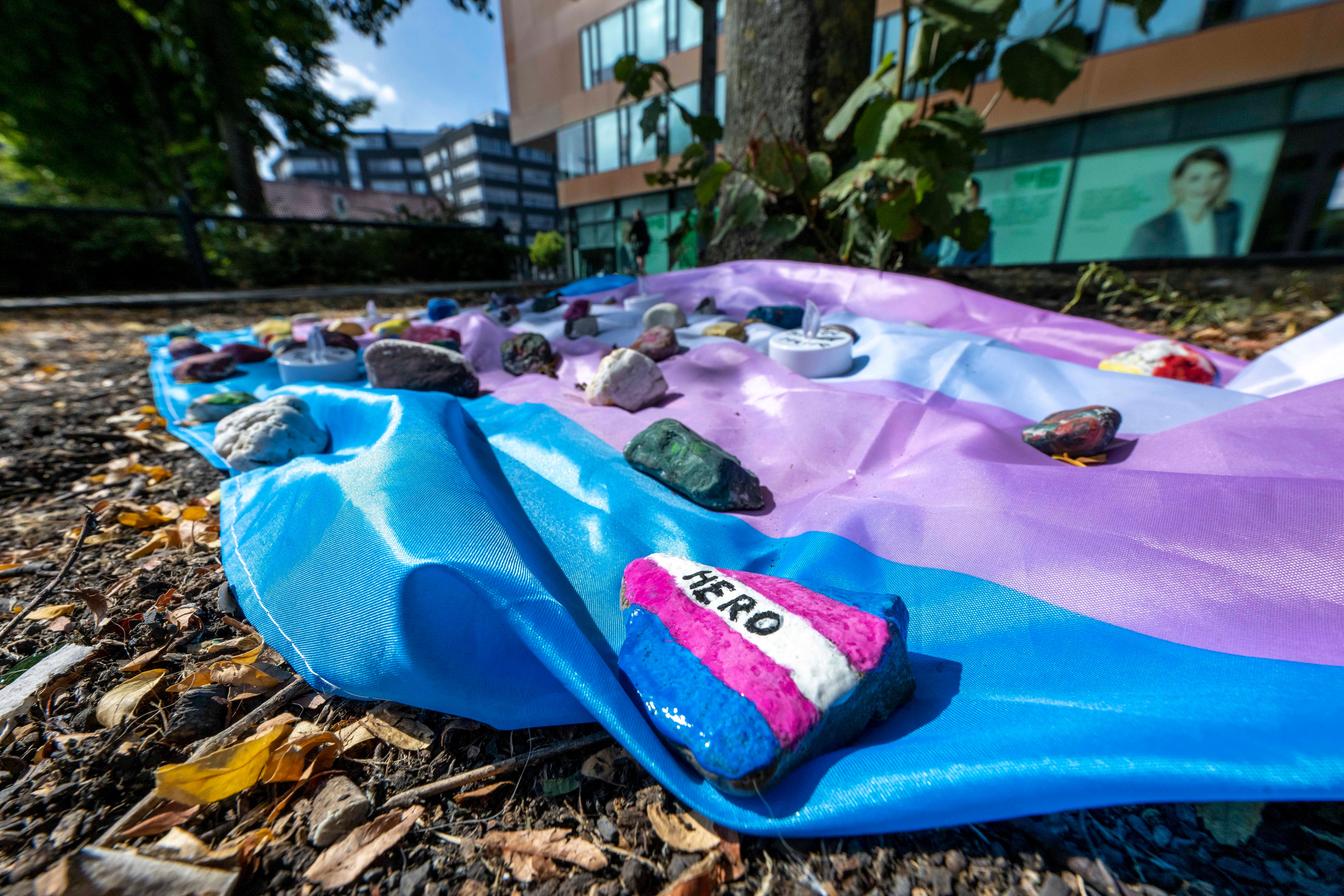 People have laid out a flag weighted down with painted stones in Muenster, Germany, to pay tribute to the 25-year-old who died after being attacked