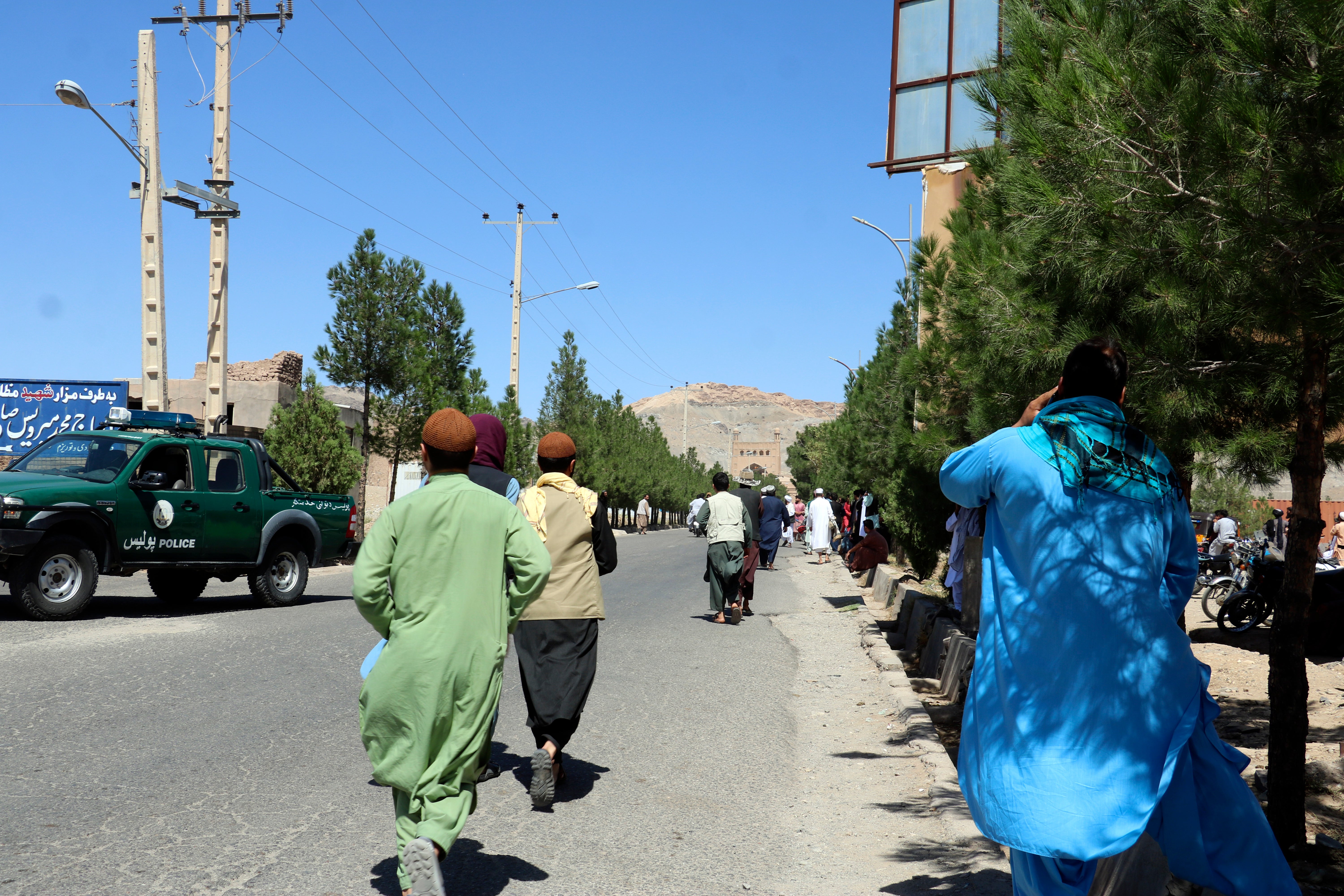 Afghan people run near the site of an explosion in Herat province in Afghanistan
