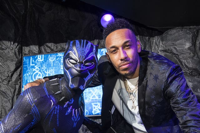 <p>Pierre-Emerick Aubameyang unveils a Black Panther waxwork at Madame Tussauds last year (Ian West/PA)</p>