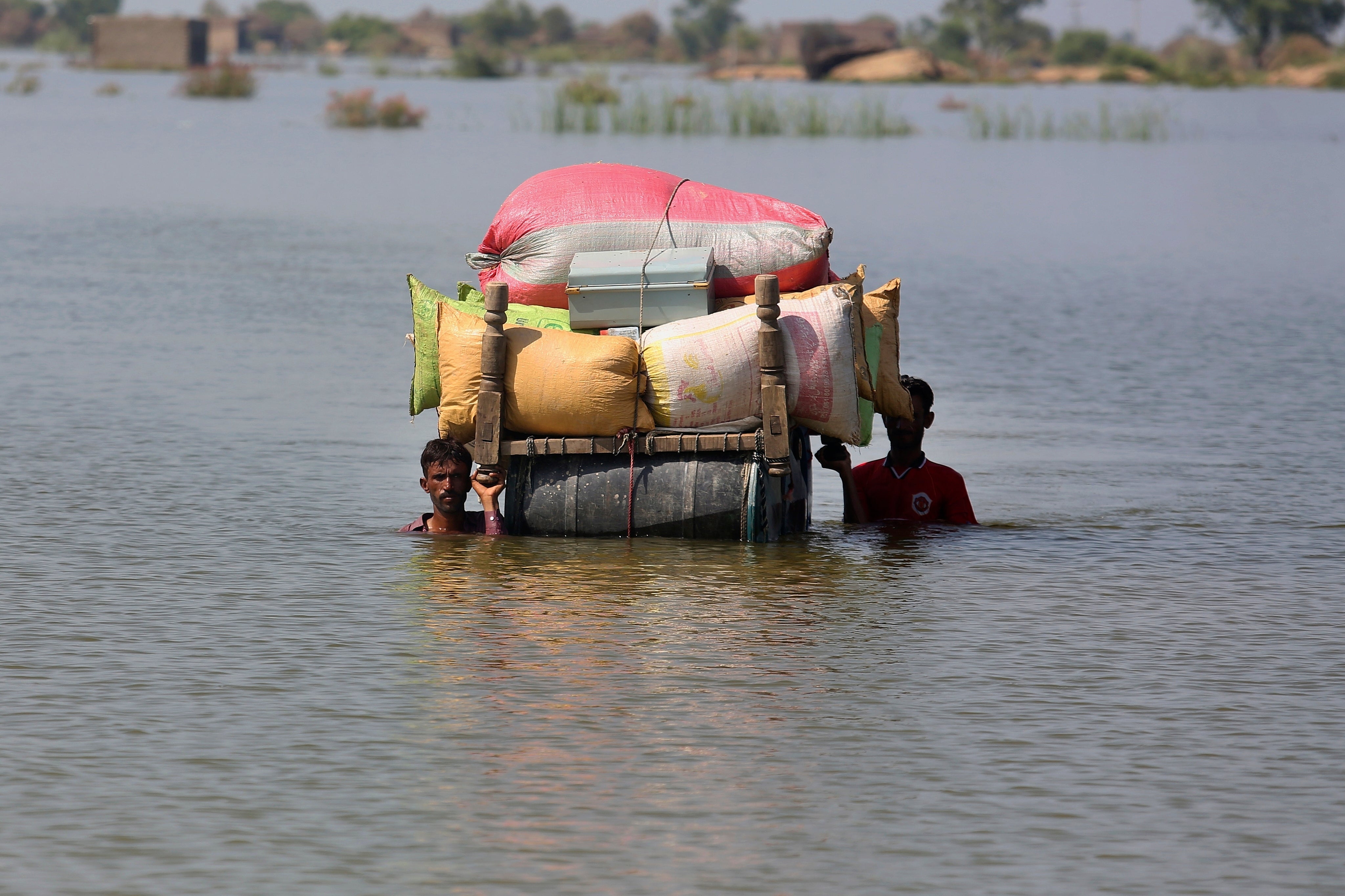 Flood-affected people try to salvage belongings (Fareed Khan/AP)