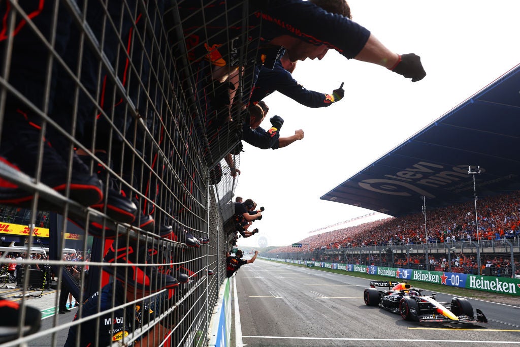 Max Verstappen passes his team celebrating on the pitwall during the F1 Grand Prix of The Netherlands at Zandvoort