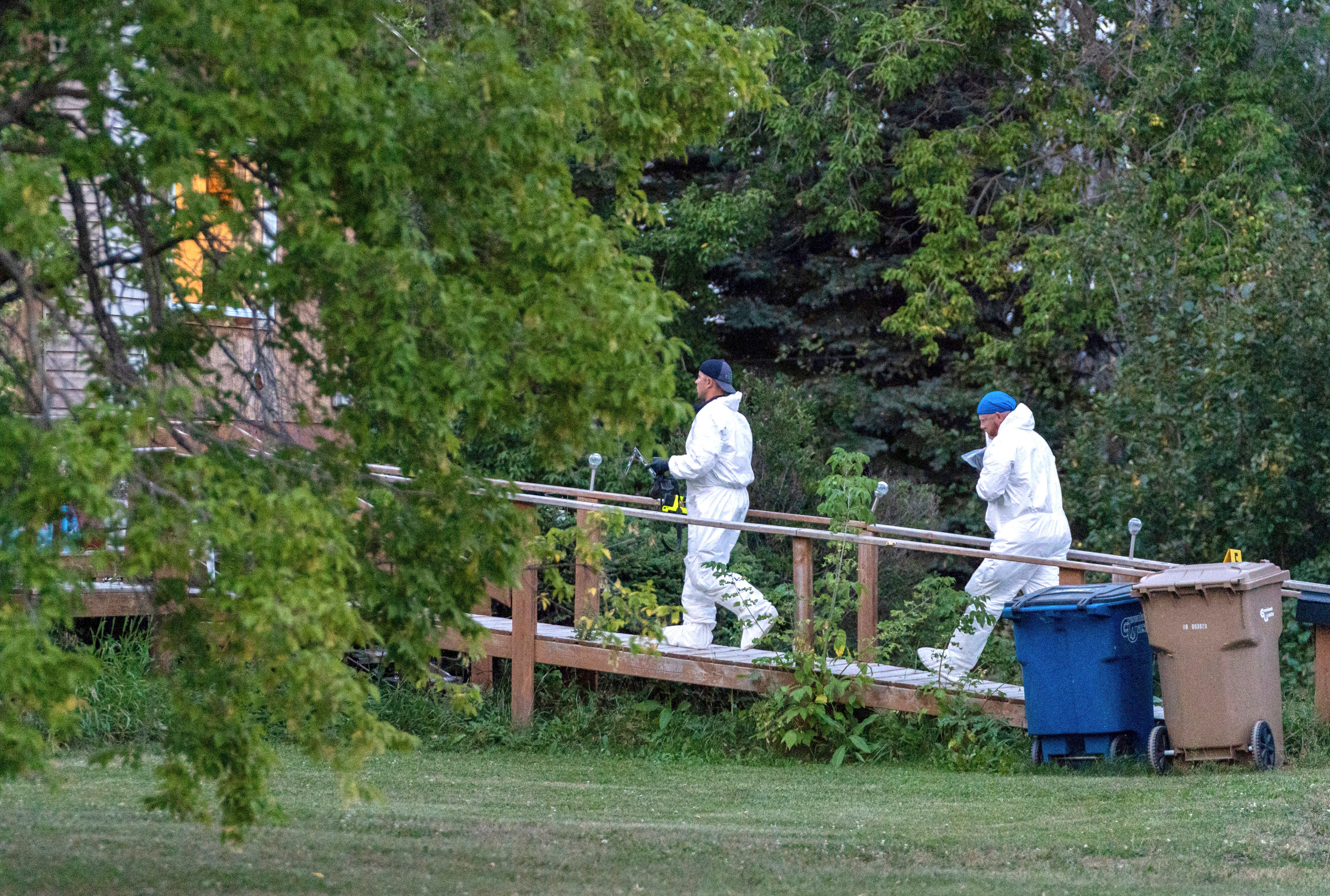 Investigators enter a house at the scene of a stabbing in Weldon, Saskatchewan, Sunday, Sept. 4, 2022