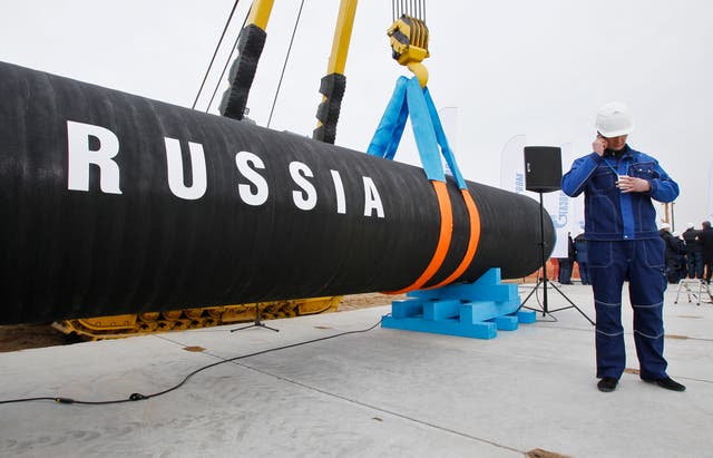 <p>A Russian construction worker speaks on a mobile phone during a ceremony marking the opening of the Nord Stream pipeline in 2010</p>