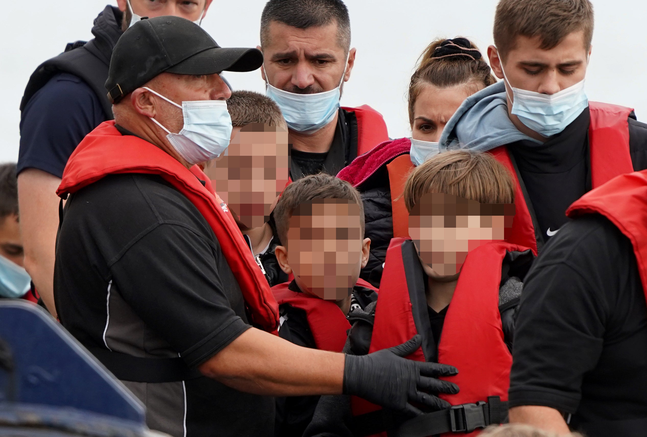 A group of people including children, thought to be migrants, are brought in to Dover, Kent, from a Border Force vessel following a small boat incident in the Channel. Picture date: Monday September 5, 2022 (Gareth Fuller/PA)