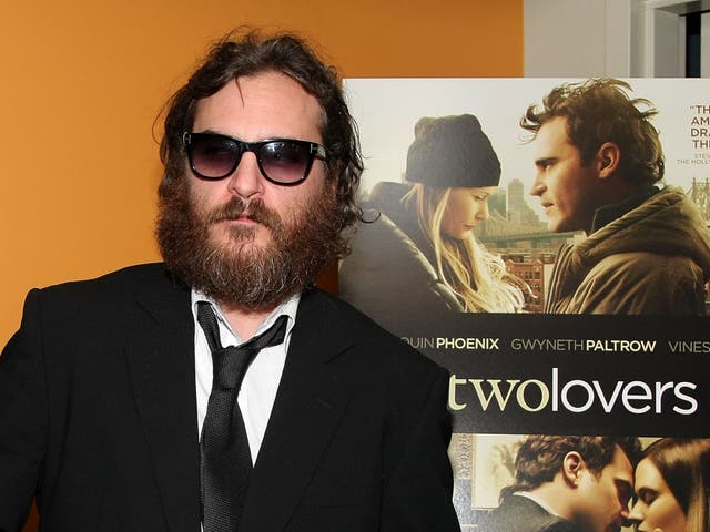 Joaquin Phoenix posa desapasionadamente frente a un cartel de su película 'Two Lovers' en 2009