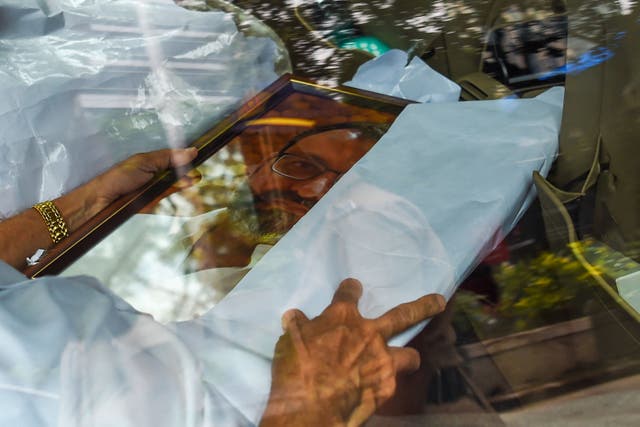 <p>A family friend holds a photo frame of Cyrus Mistry, the former chairman of Tata Group, after his funeral at a crematorium in Mumbai </p>