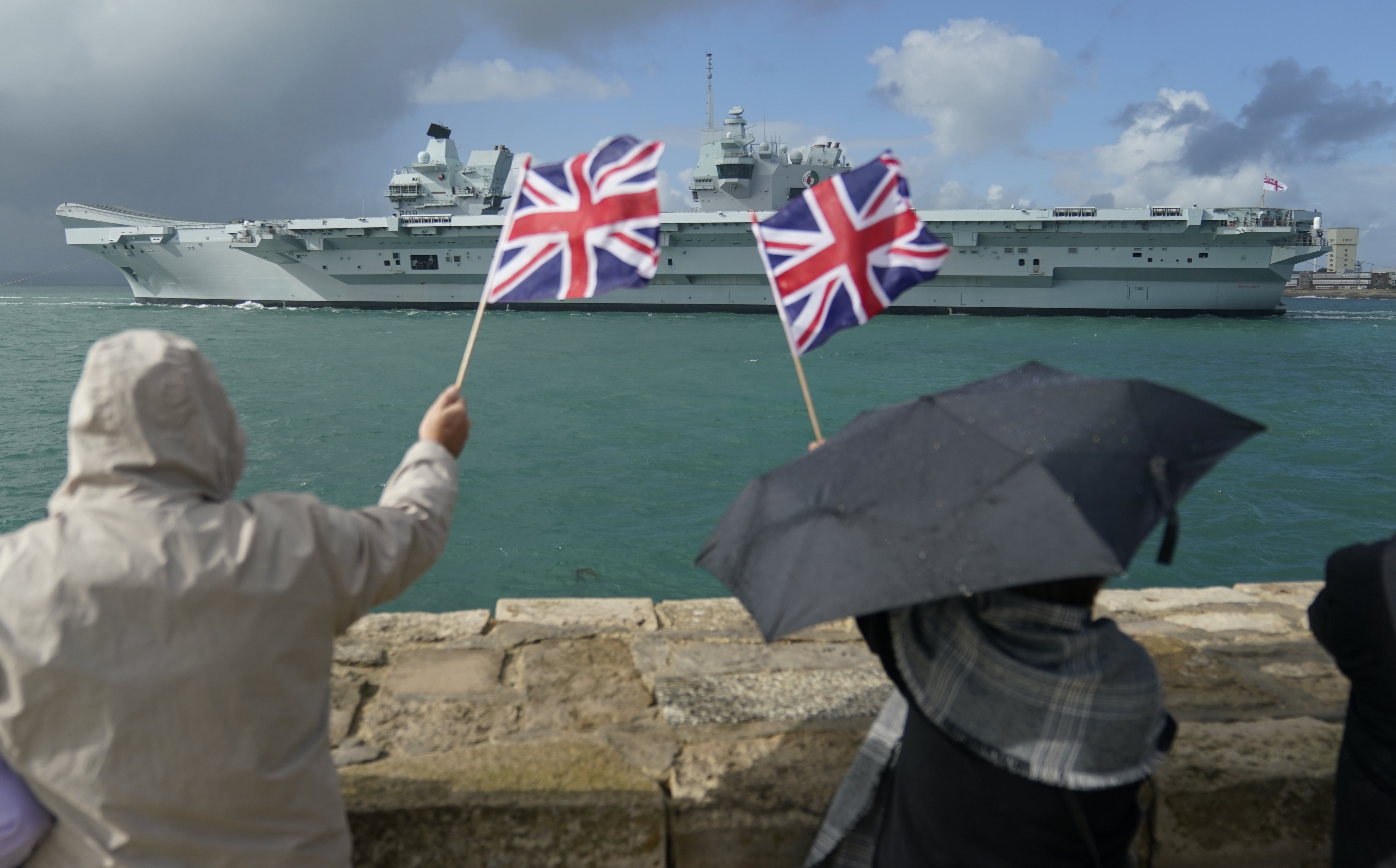 People wave from the shore as the Royal Navy aircraft carrier and flagship HMS Queen Elizabeth leaves Portsmouth Harbour for the United States, ahead of an autumn on operations and exercises in European waters. Picture date: Wednesday September 7, 2022. (Andrew Matthews/PA Wire)
