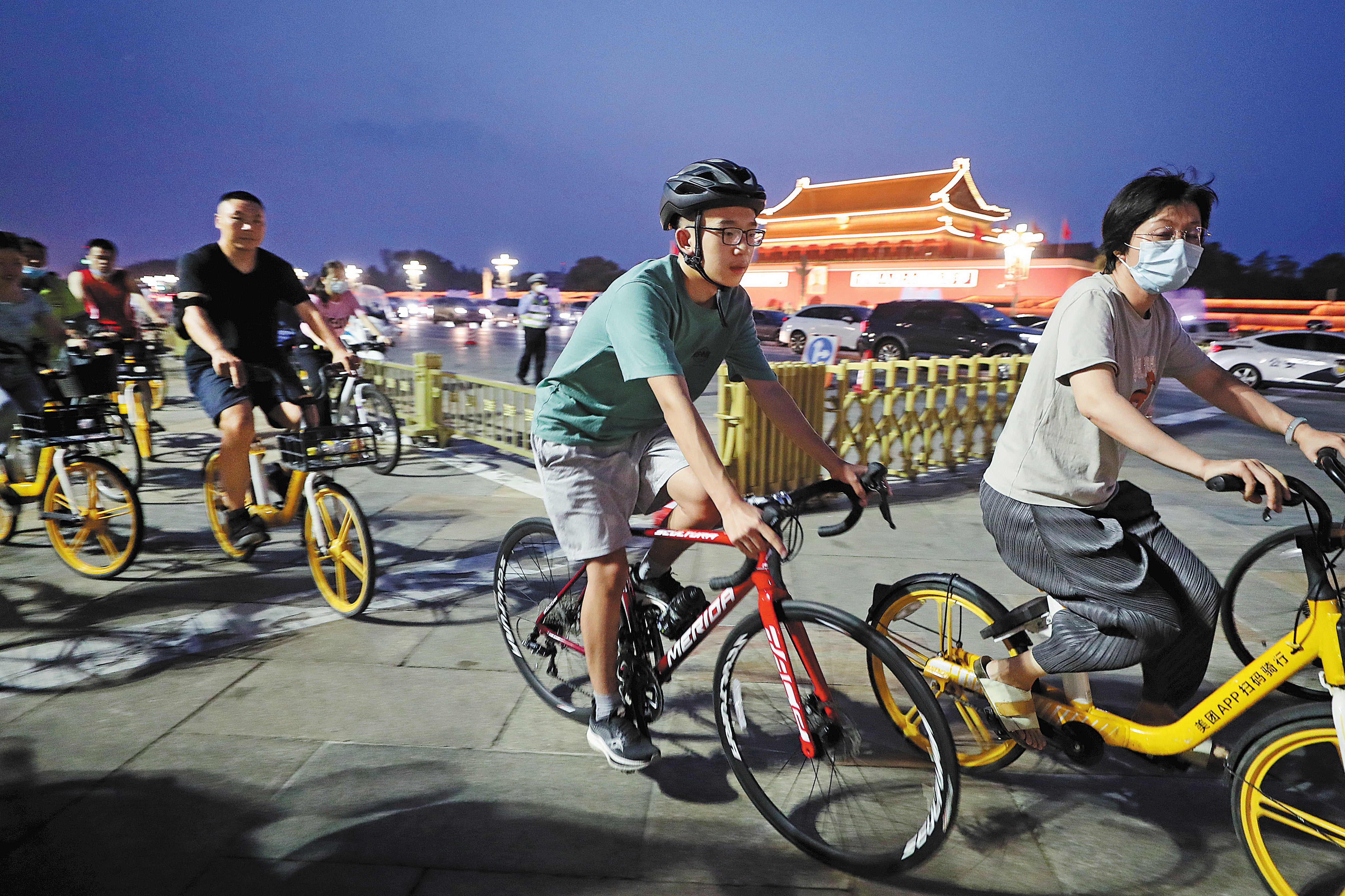 Cyclists pass through Tian’anmen Square in Beijing in July during an evening ride along Chang’an Avenue, where many of them take photos of the area at sunset