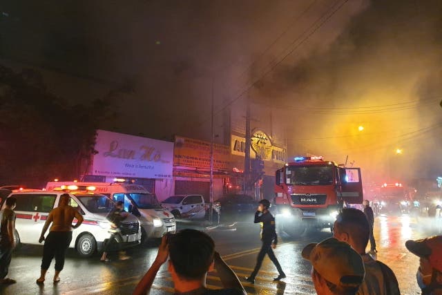 <p>Firefighters work at the scene of a fire at a karaoke bar in Binh Duong province</p>