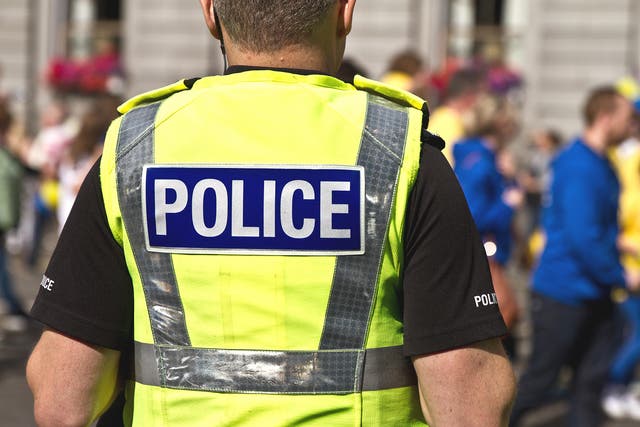 Police officer in hi-visibility jacket with ‘Police’ written on it (Alamy/PA)