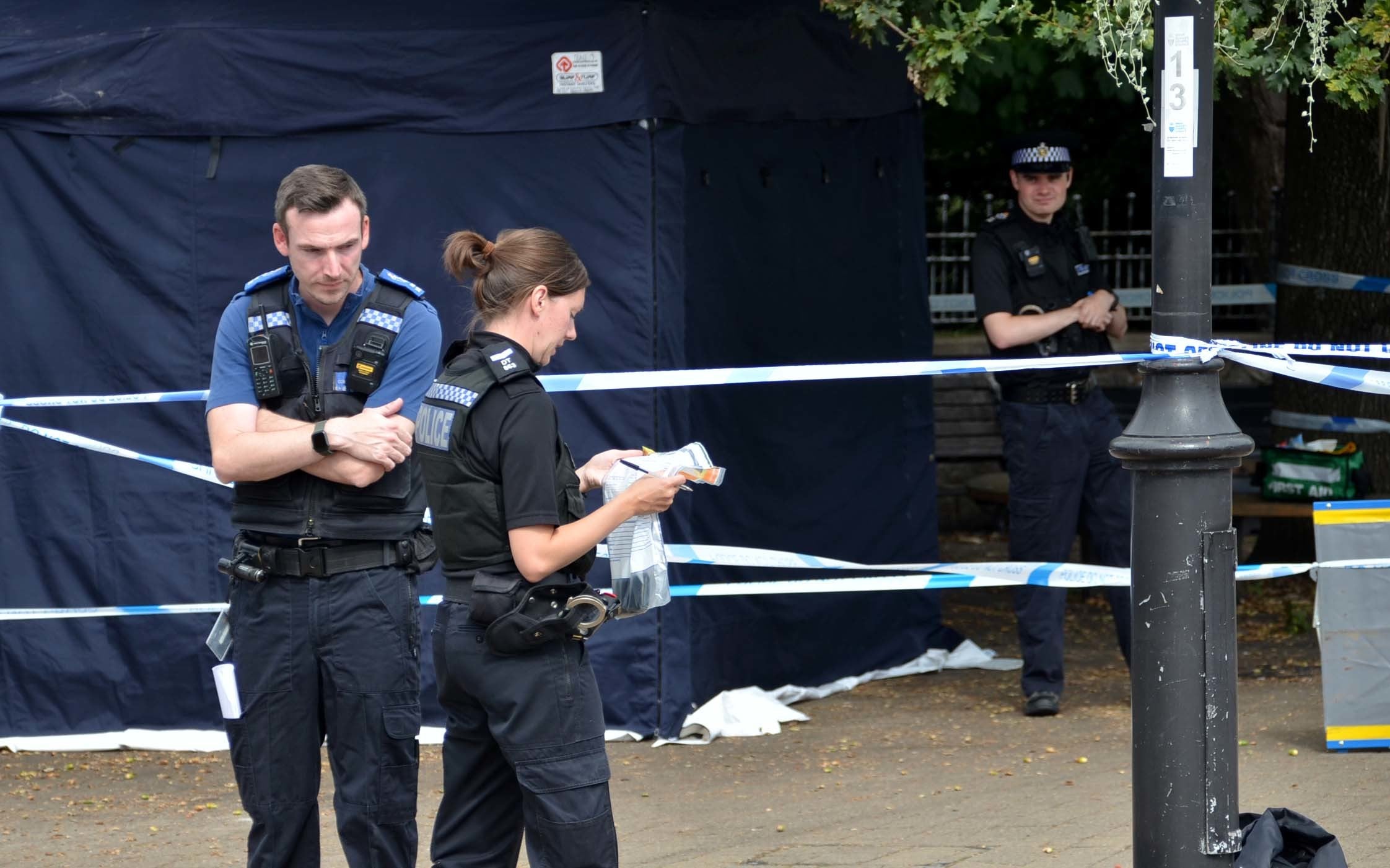 Police officers stand next to a police tent at the scene on at Place de Villerest on the junction of Old Mill Drive and the High Street in Storrington, West Sussex, after a man died (Clive Gee/PA)