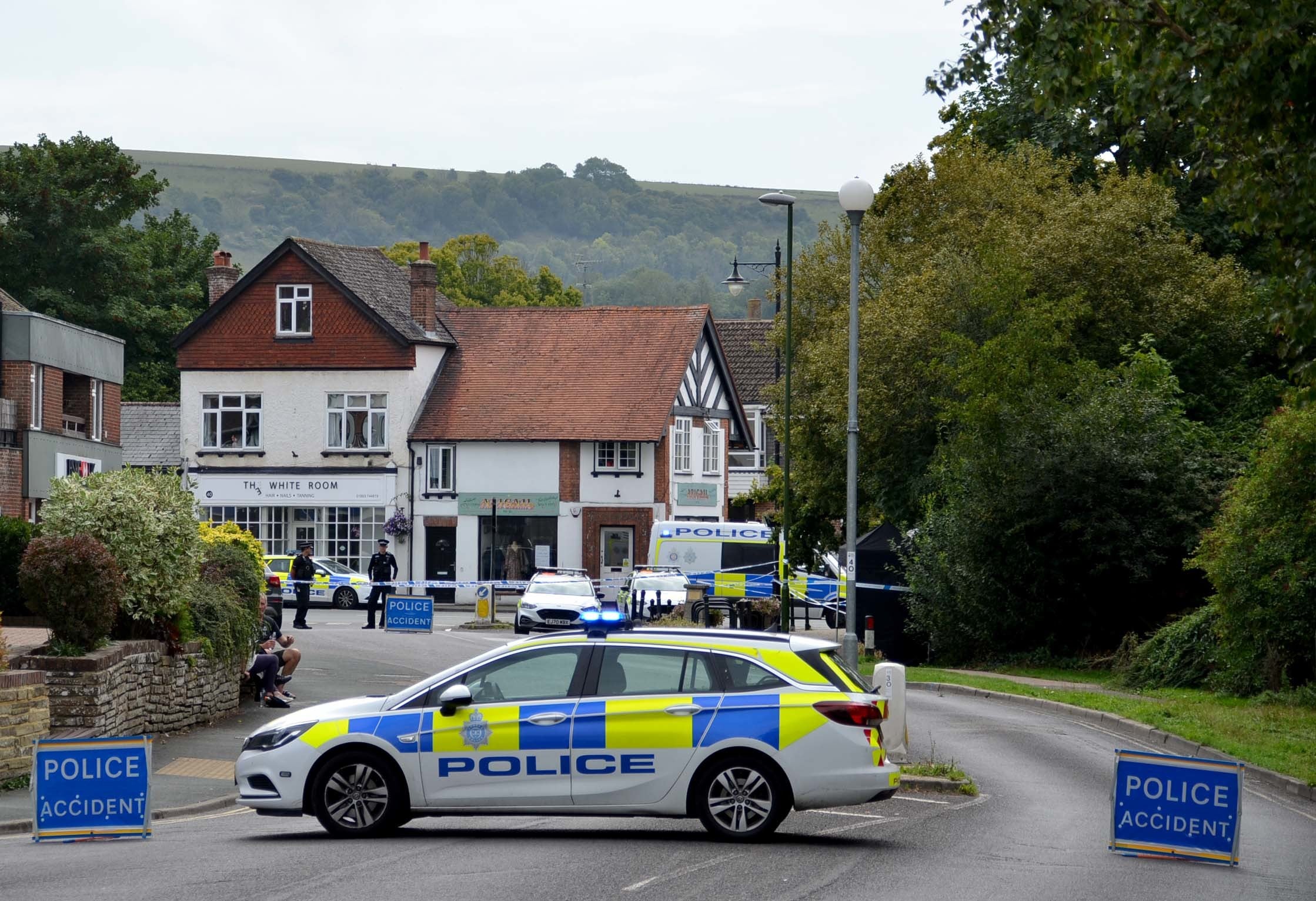 Police vehicles on Old Mill Drive in Storrington, West Sussex, near to the scene, after a man died (PA)