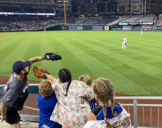 <p>An adult at a Nationals game earlier this month caught a ball with a glove as children excitedly clamoured to get it</p>