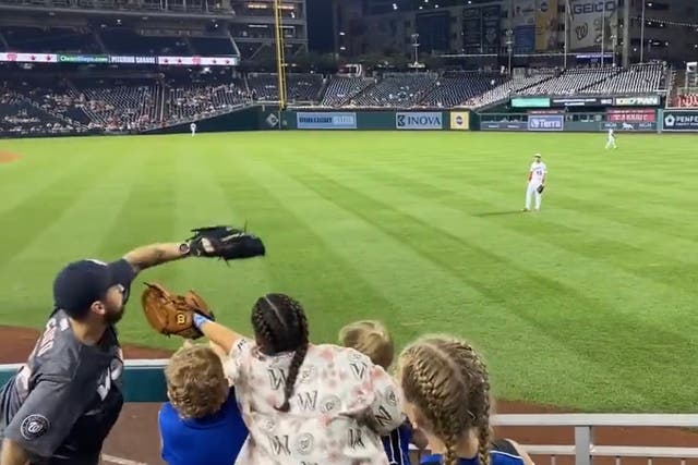 <p>An adult at a Nationals game earlier this month caught a ball with a glove as children excitedly clamoured to get it</p>