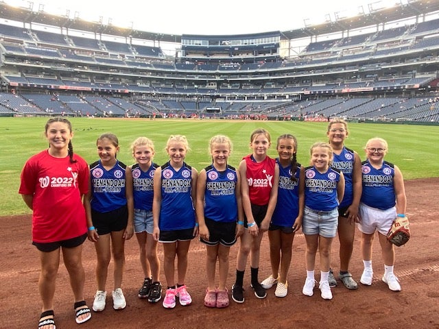 Ms Hilliard’s 10-year-old daughter poses with teammates at the Nationals game, which they attended after their state softball victory