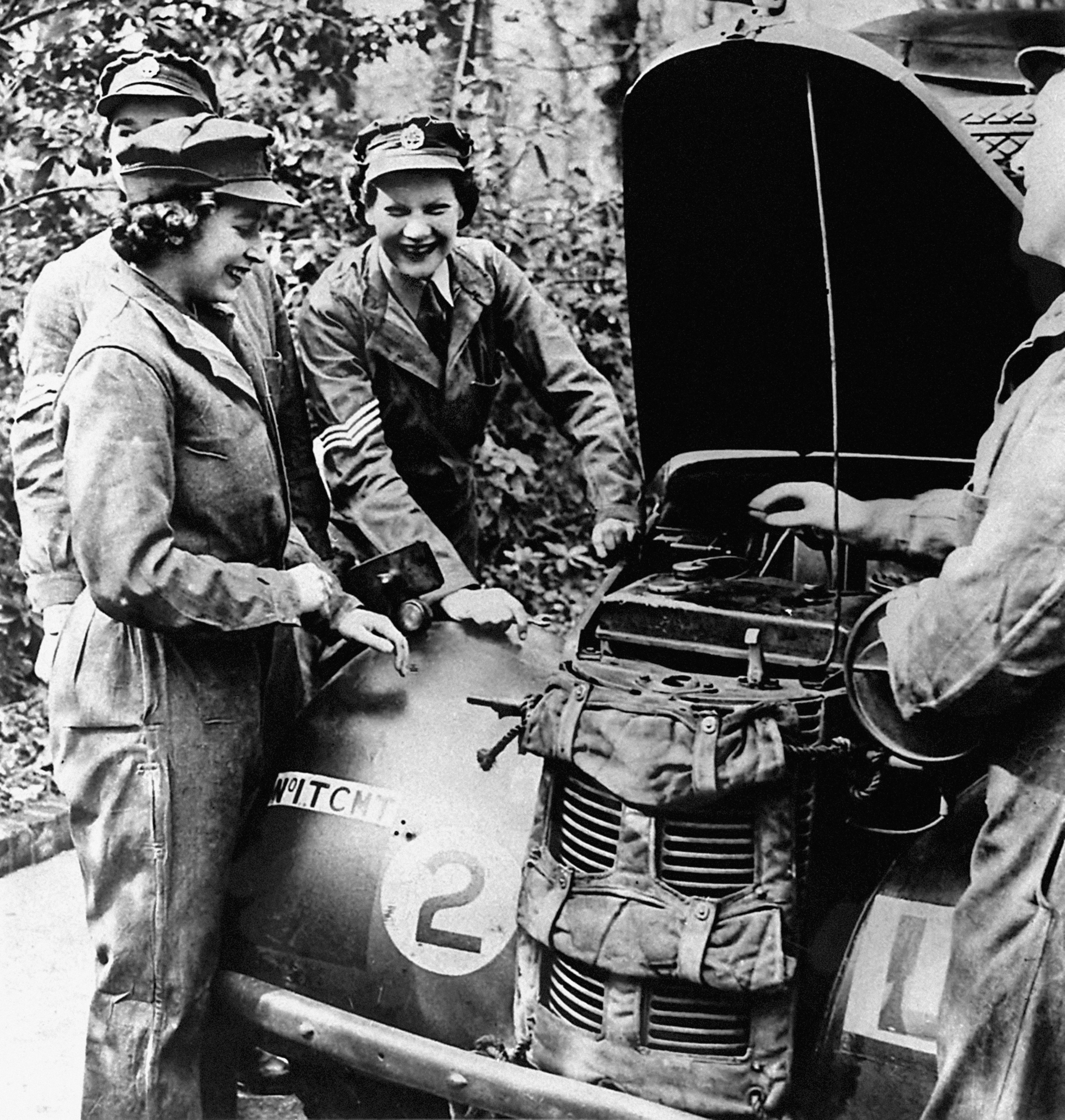 Princess Elizabeth receives vehicle maintenance instruction on an Austin 10 Light Utility Vehicle while serving with No 1 MTTC at Camberley, Surrey.
