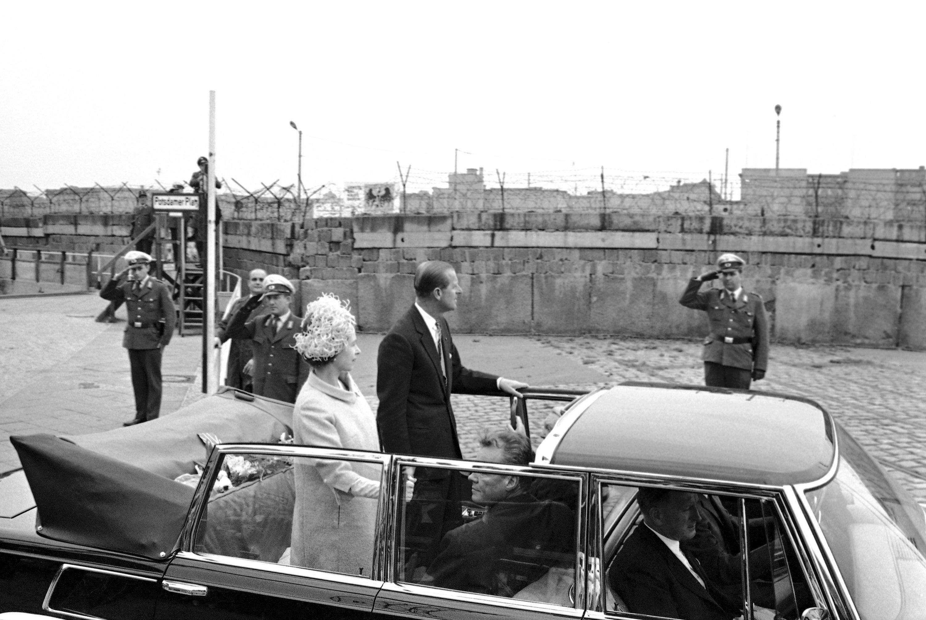 Queen Elizabeth II and Prince Philip drive by the Berlin Wall in 1965