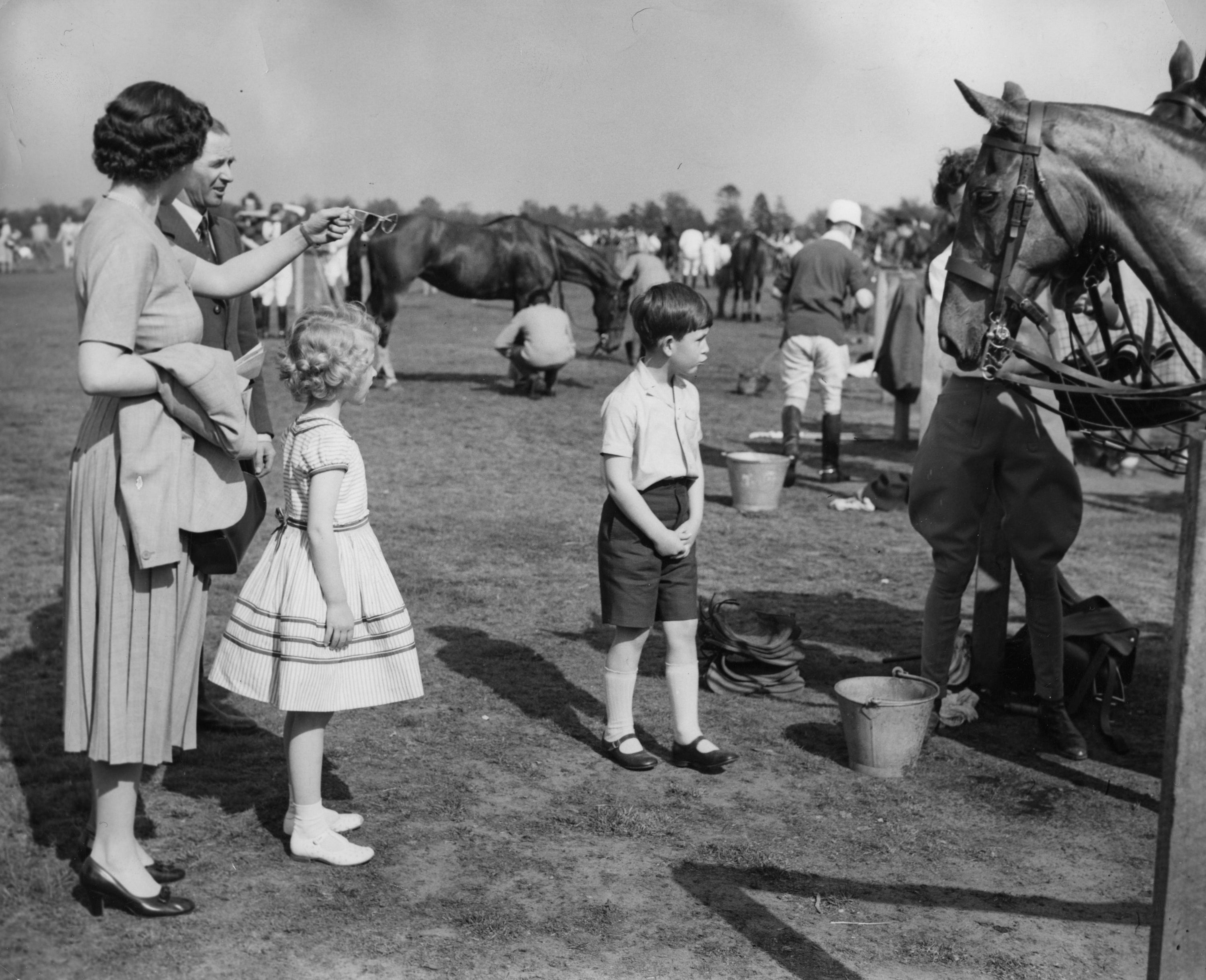 Queen Elizabeth II with Prince Charles and Princess Anne visiting the polo ponies during a break in the polo tournament, in which the Duke of Edinburgh was playing at Smith’s Lawn in Windsor Great Park in 1956 (PA Archive)