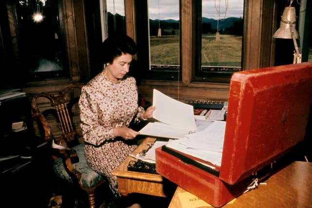 The Queen working through her red box of official papers at Balmoral (PA)