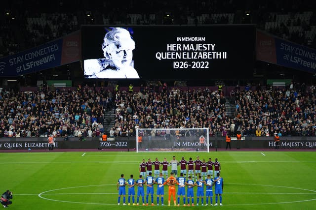 Players pay tribute to the Queen before kick-off (PA)