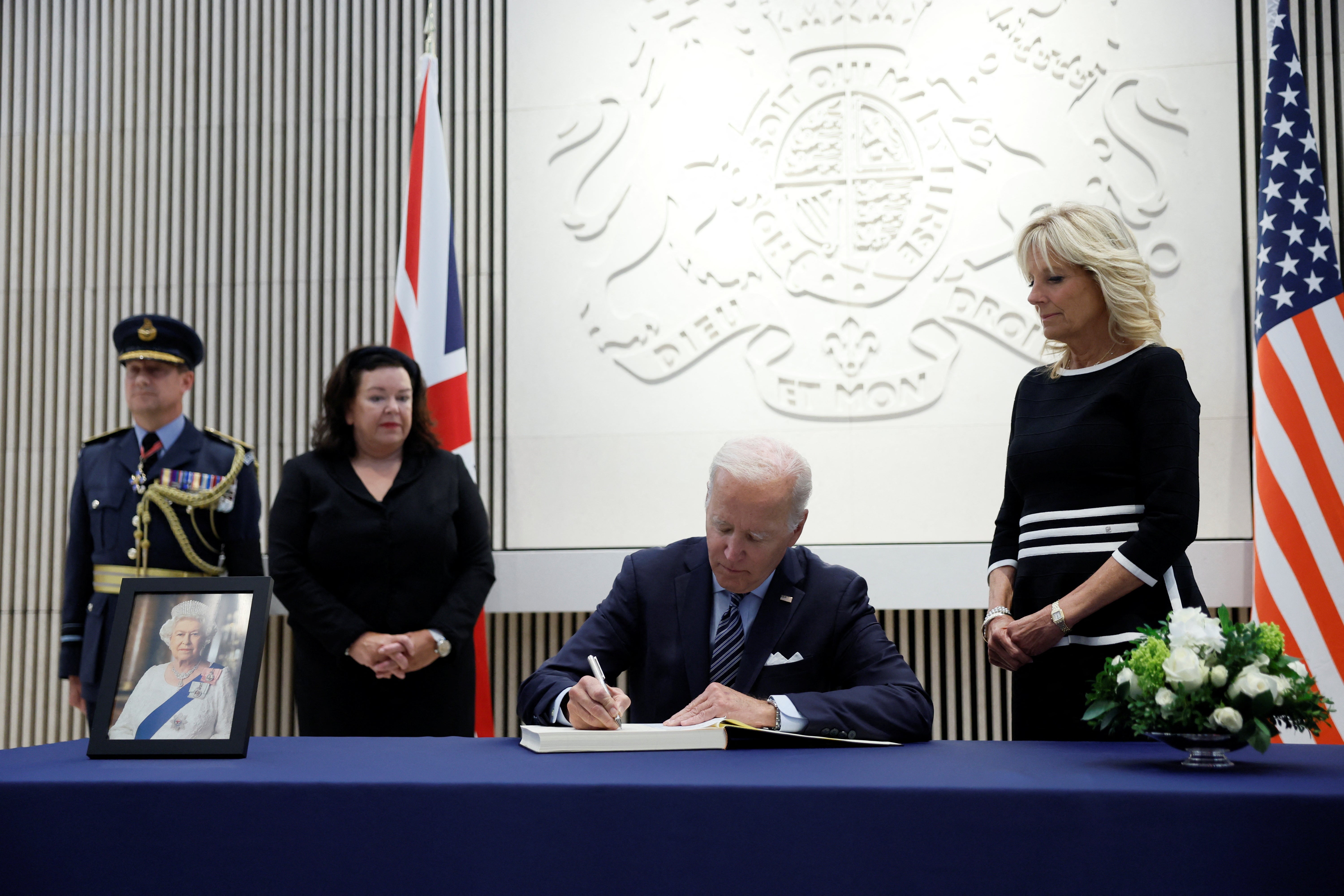 Joe Biden signs a condolence book at the UK embassy in Washington DC as first lady Jill Biden looks on