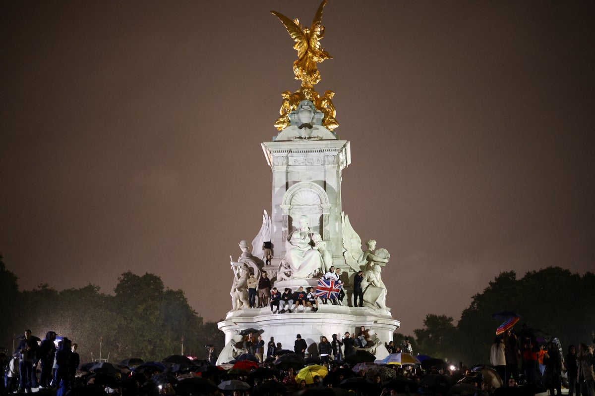 ‘I thought she’d live forever’: Thousands brave rain to mourn the Queen outside Buckingham Palace