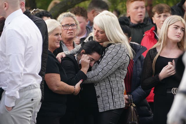 Margaret Cash McDonagh, the mother of Lisa Cash, 18, and her eight-year-old twin siblings, Christy and Chelsea Cawley, is consoled as the coffins of her children arrive at St Aidan’s Church, Brookfield, Tallaght, ahead of their removal service (Brian Lawless/PA)