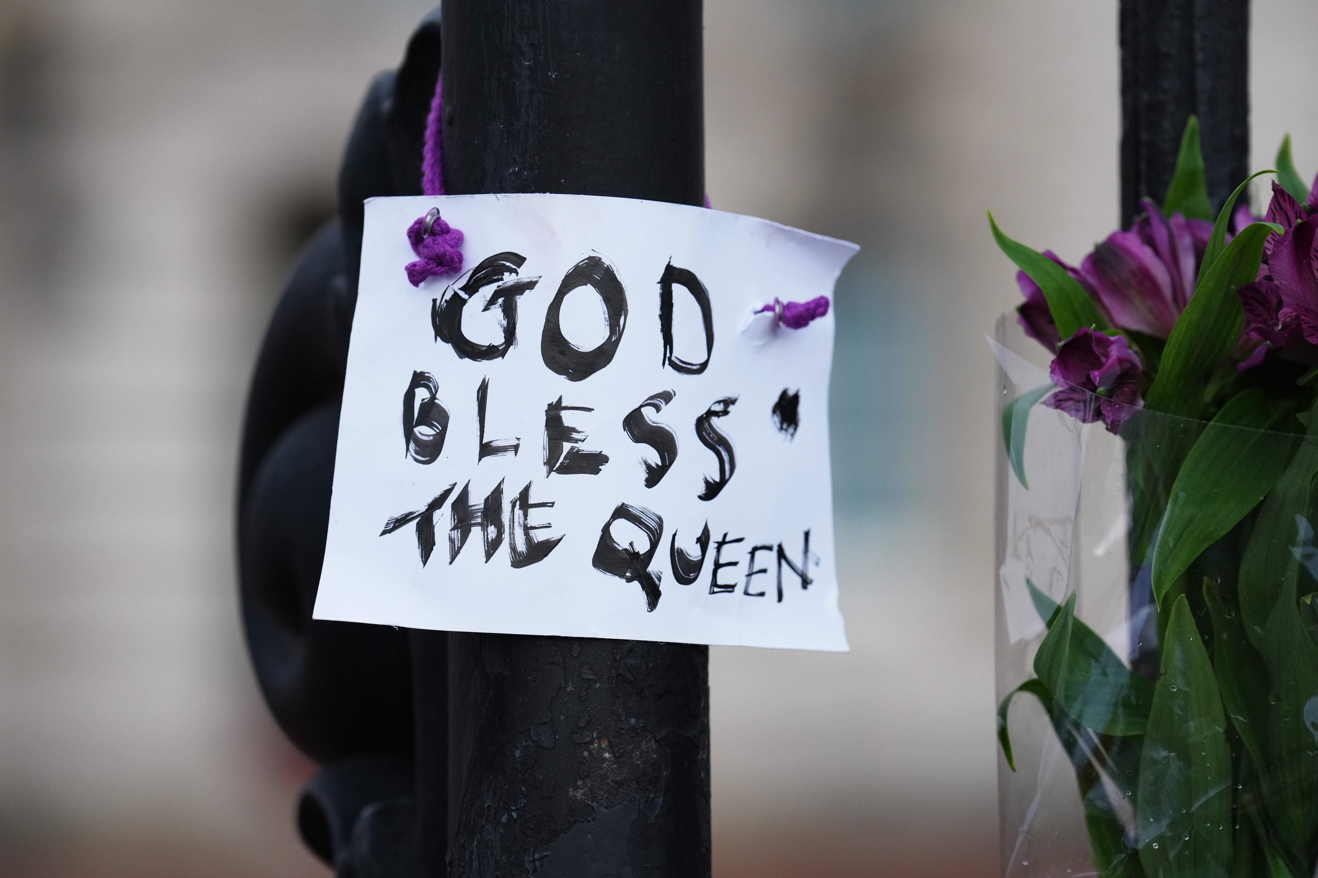 A tribute to the Queen is posted on the railings of Buckingham Palace.