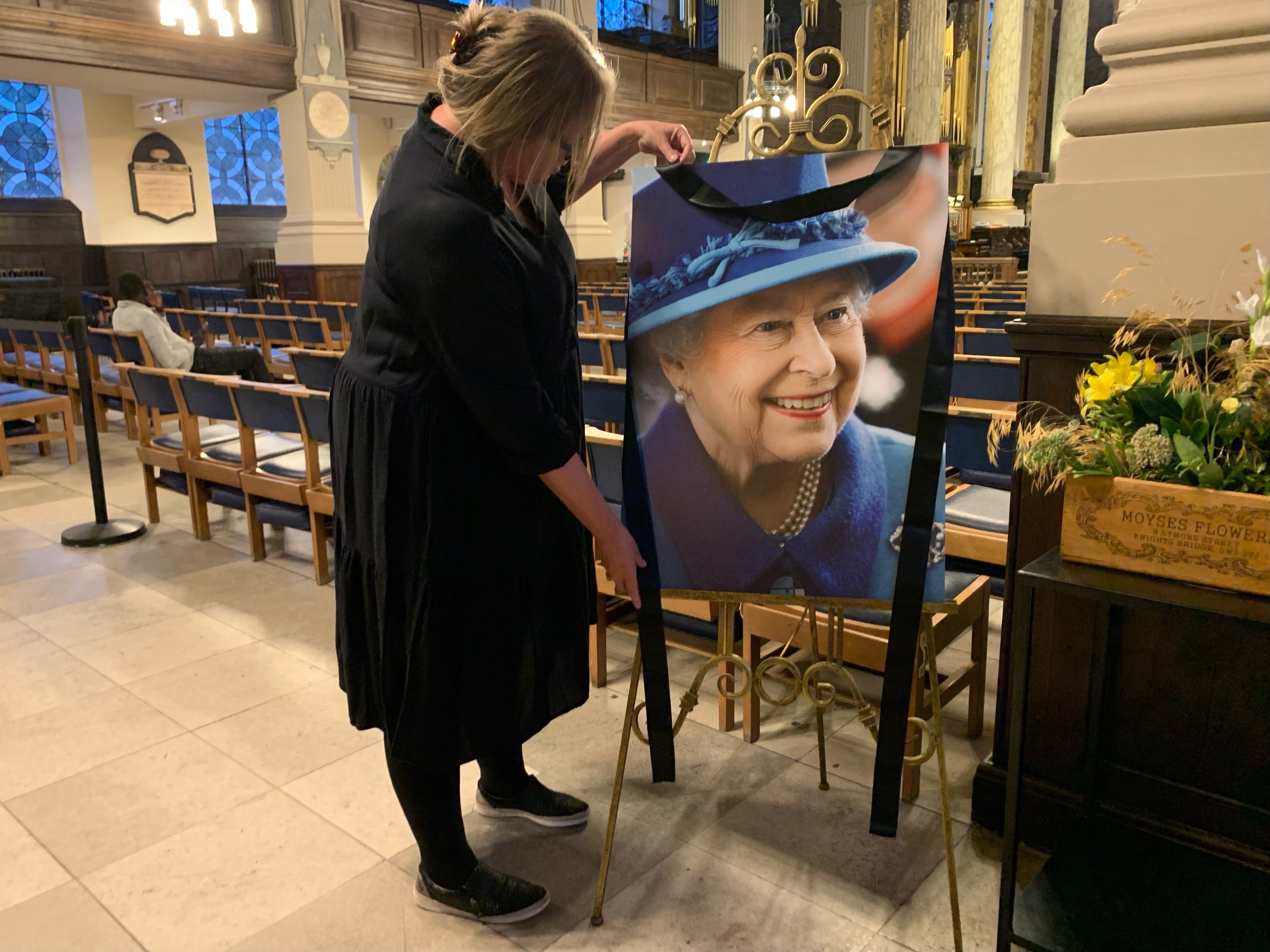 Anna Pitt, chief executive of Birmingham’s St Philip’s Cathedral putting out a picture of Queen Elizabeth II following the announcement of her death (Richard Vernalls/PA)