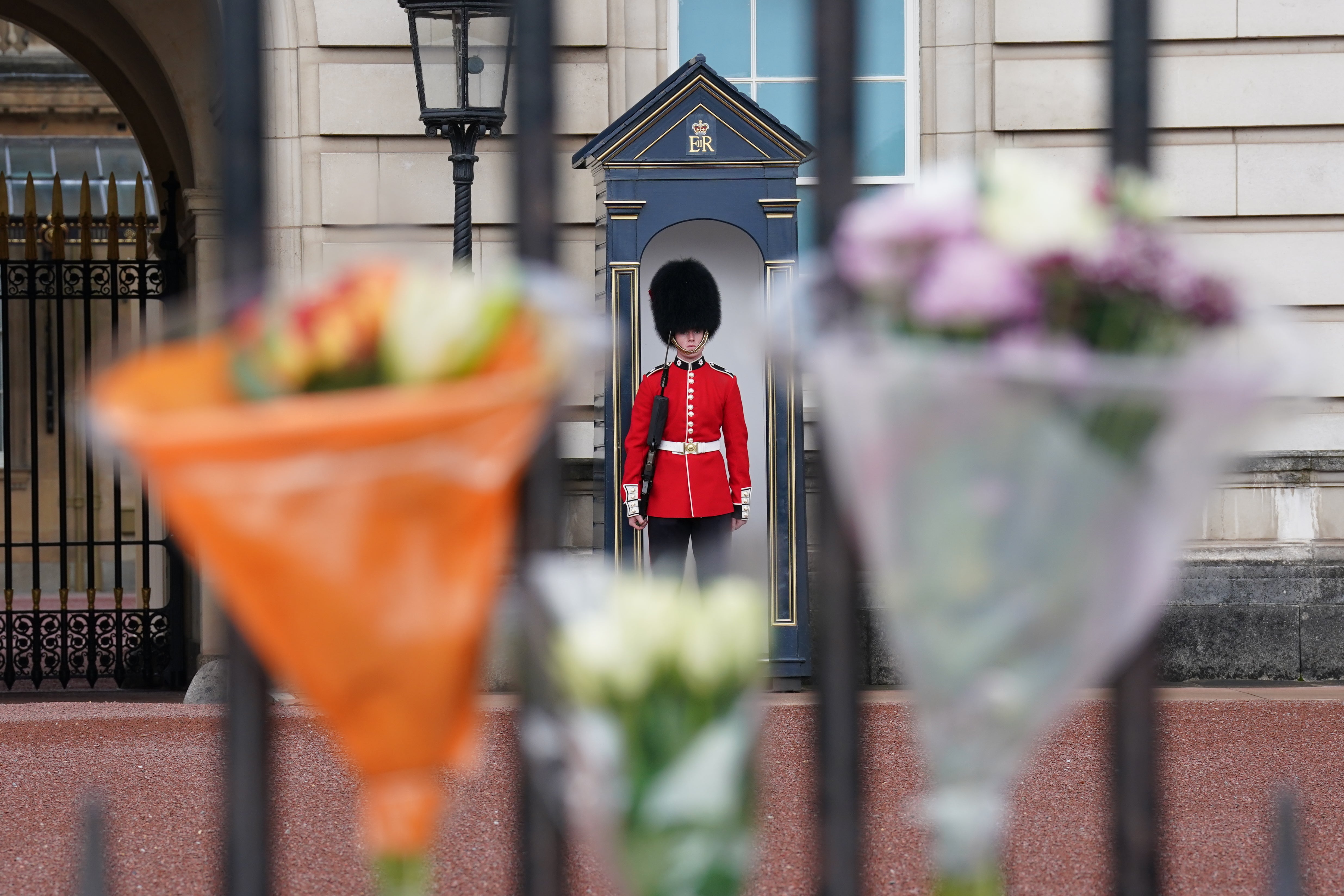Bouquets of flowers left on the gates at Buckingham Palace (Kirsty O’Connor/PA)