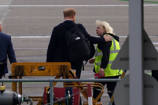 <p>Prince Harry was accompanied by a woman wearing a hi-vis vest, whom he spoke with and at one stage placed his hand on her shoulder</p>