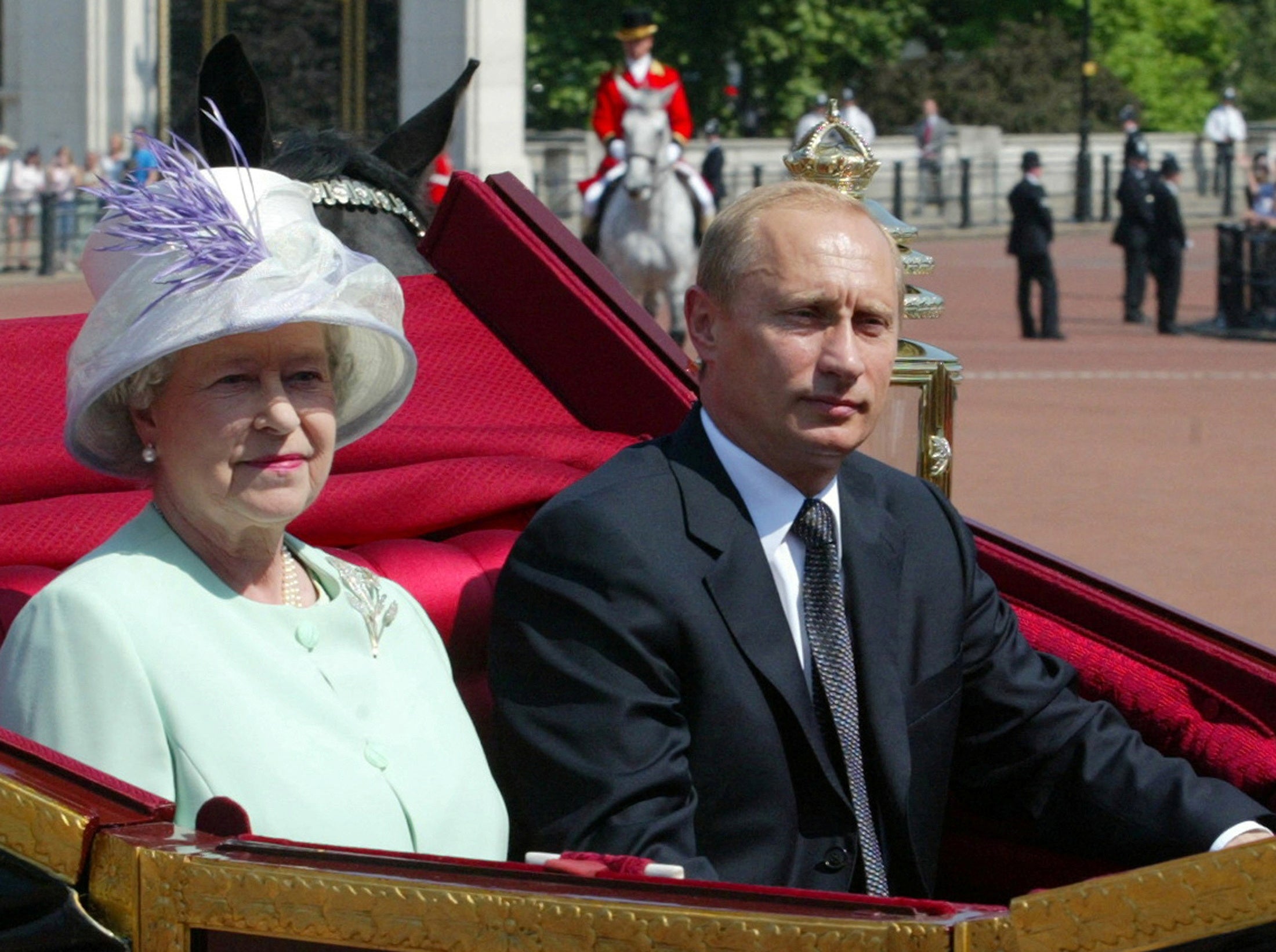 A carriage carrying Britain's Queen Elizabeth II and Russian President Vladimir Putin is escorted by royal guards to Buckingham Palace in central London, Britain, June 24, 2003.