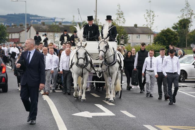 Mourners walk behind a horse drawn hearse carrying the coffins of Lisa Cash, 18, and her eight-year-old twin siblings, Christy and Chelsea Cawley, after their funeral service at St Aidan’s Church, Brookfield, Tallaght (Brian Lawless/PA)