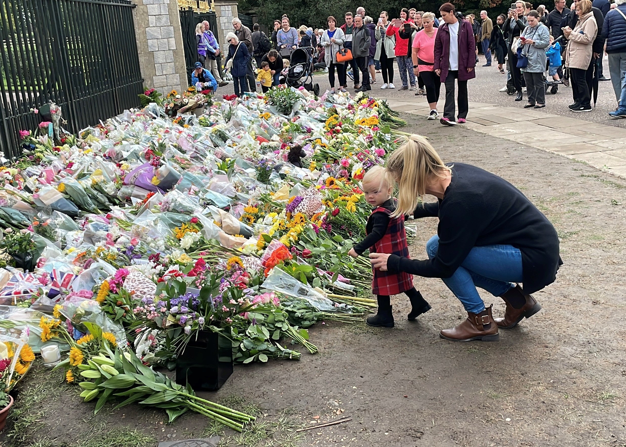 Amanda Bartlett with her daughter Ayla lay flowers at Cambridge Gate, Long Walk, Windsor (Ben Mitchell/PA)