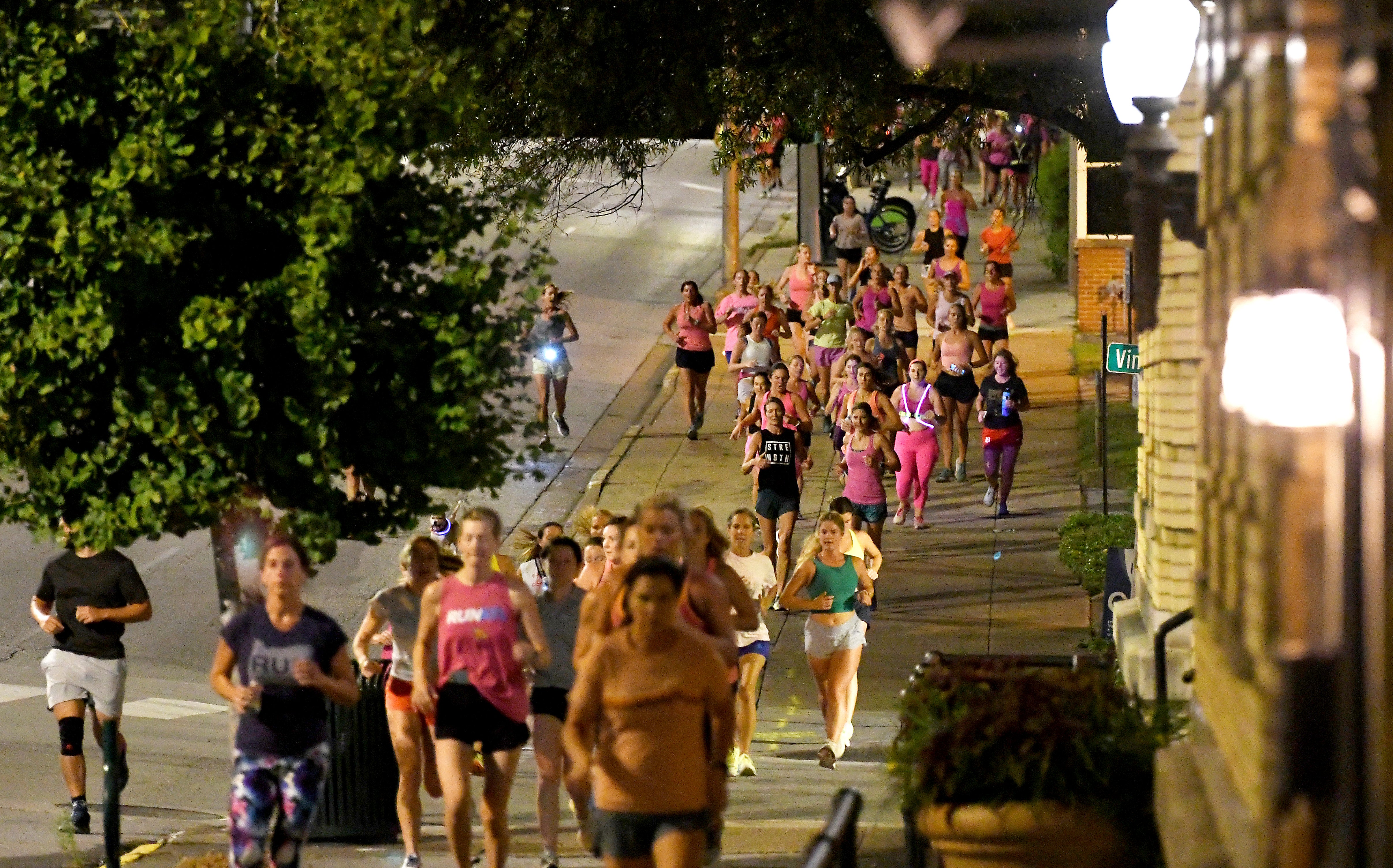 Runners head down the sidewalk past Fountain Square on Georgia Avenue during ‘Finish Eliza’s Run’ on Friday morning