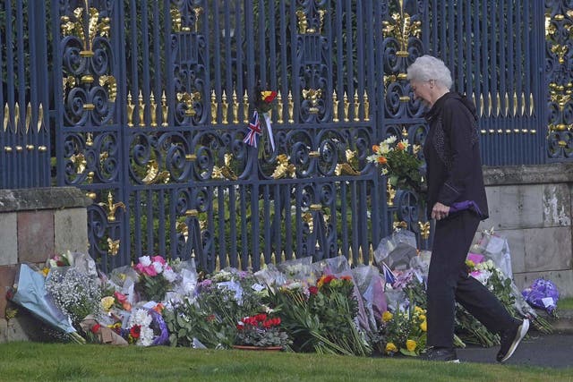 Lady Mary Elizabeth Peters lays flowers at the gates of Hillsborough Castle in Co Down, as she pays her respects (Mark Marlow/PA)
