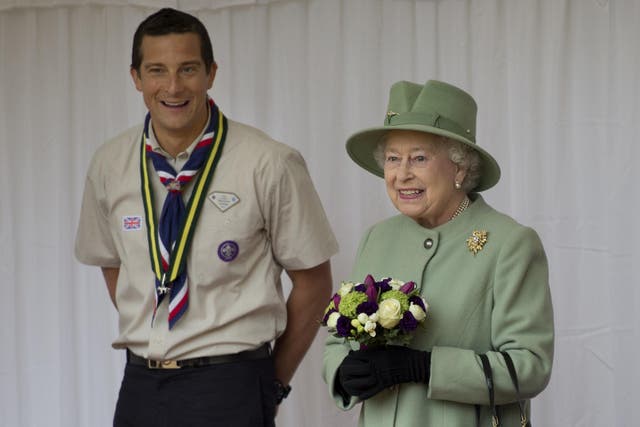 <p>Chief Scout, Bear Grylls, left, watches as Queen Elizabeth II reviews the Queen’s Scouts at Windsor Castle (Ben Stansall/PA)</p>