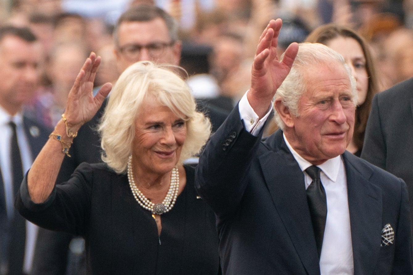 King Charles III and the Queen wave to the crowd outside Buckingham Palace (PA)