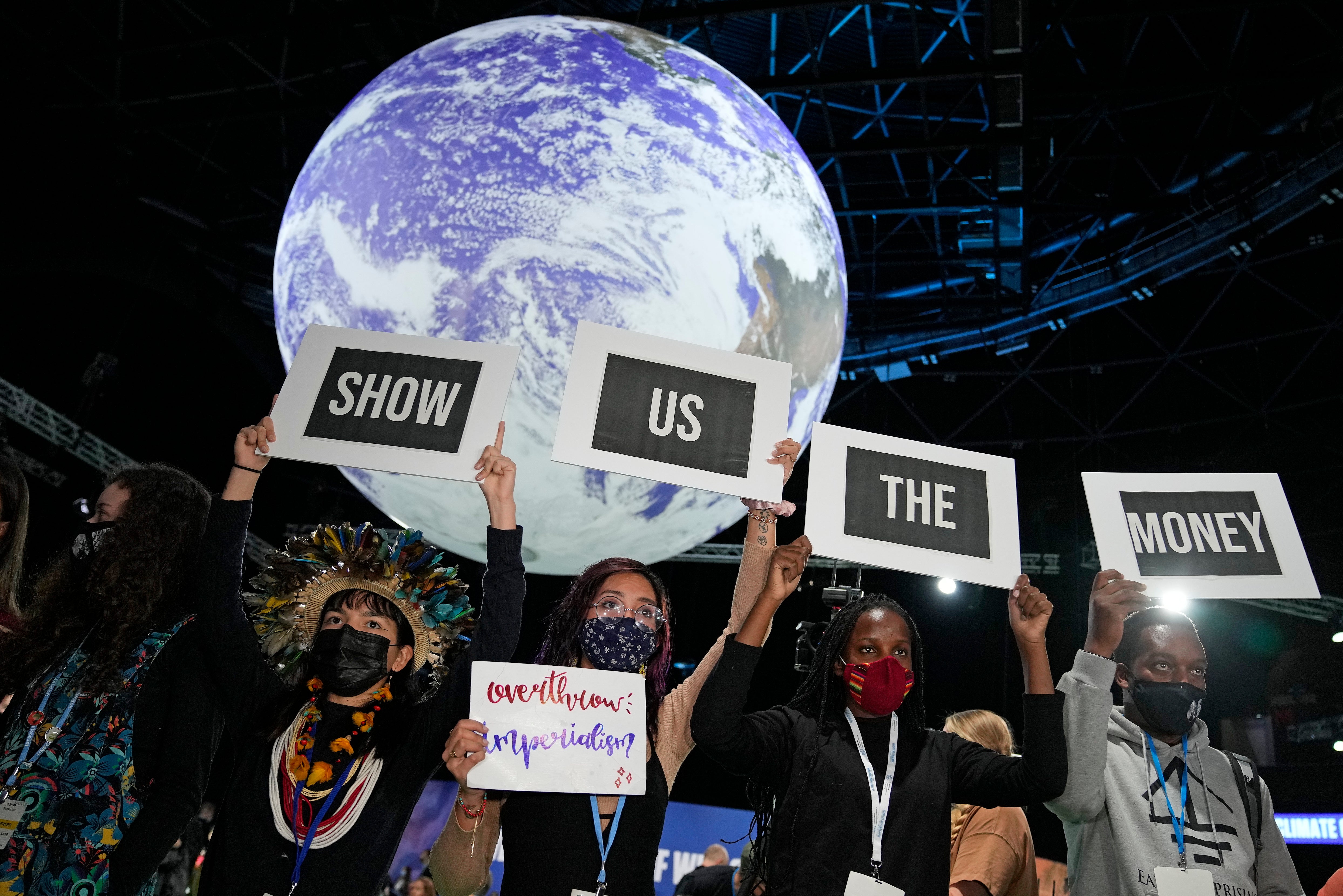 Climate protesters hold up signs at the UN